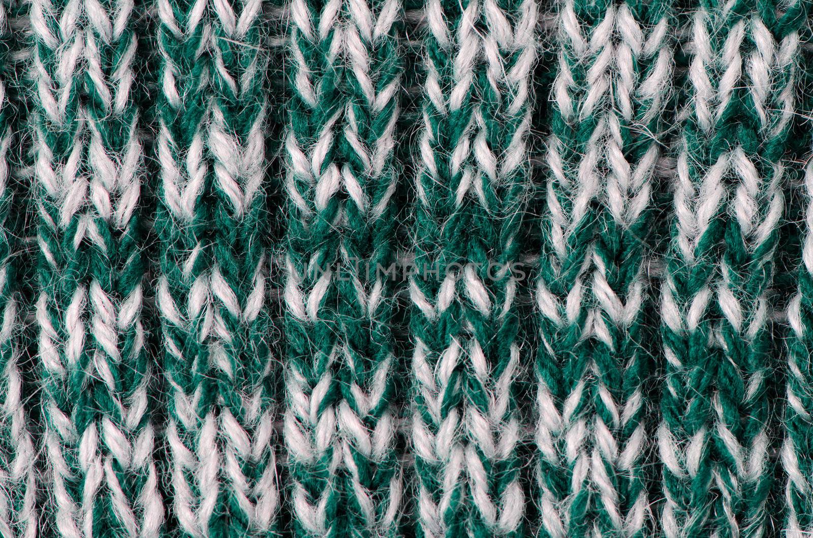 Knit woolen texture. Fabric green and white background.
