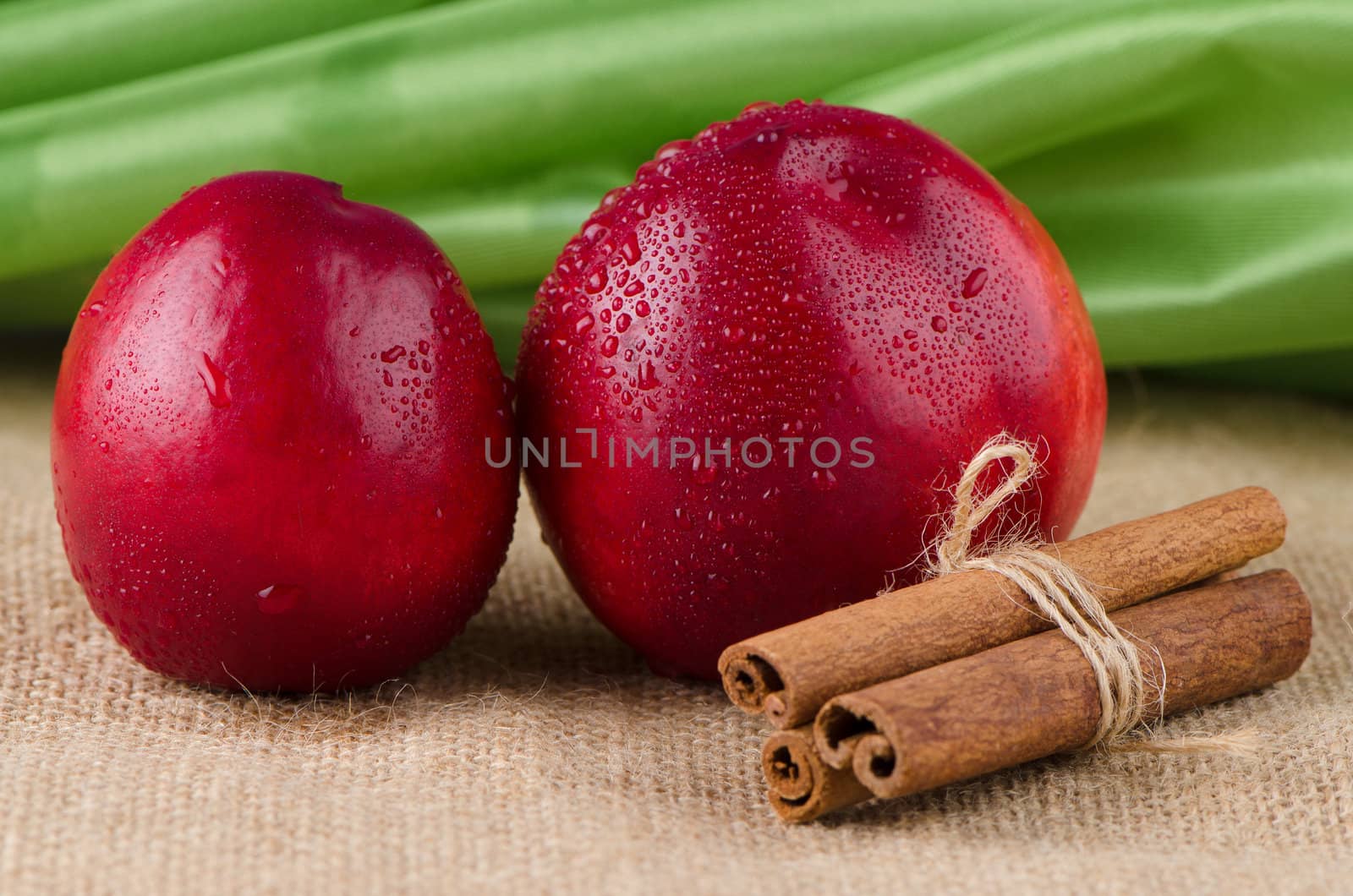 Peaches  and cinnamon sticks over rafia background.