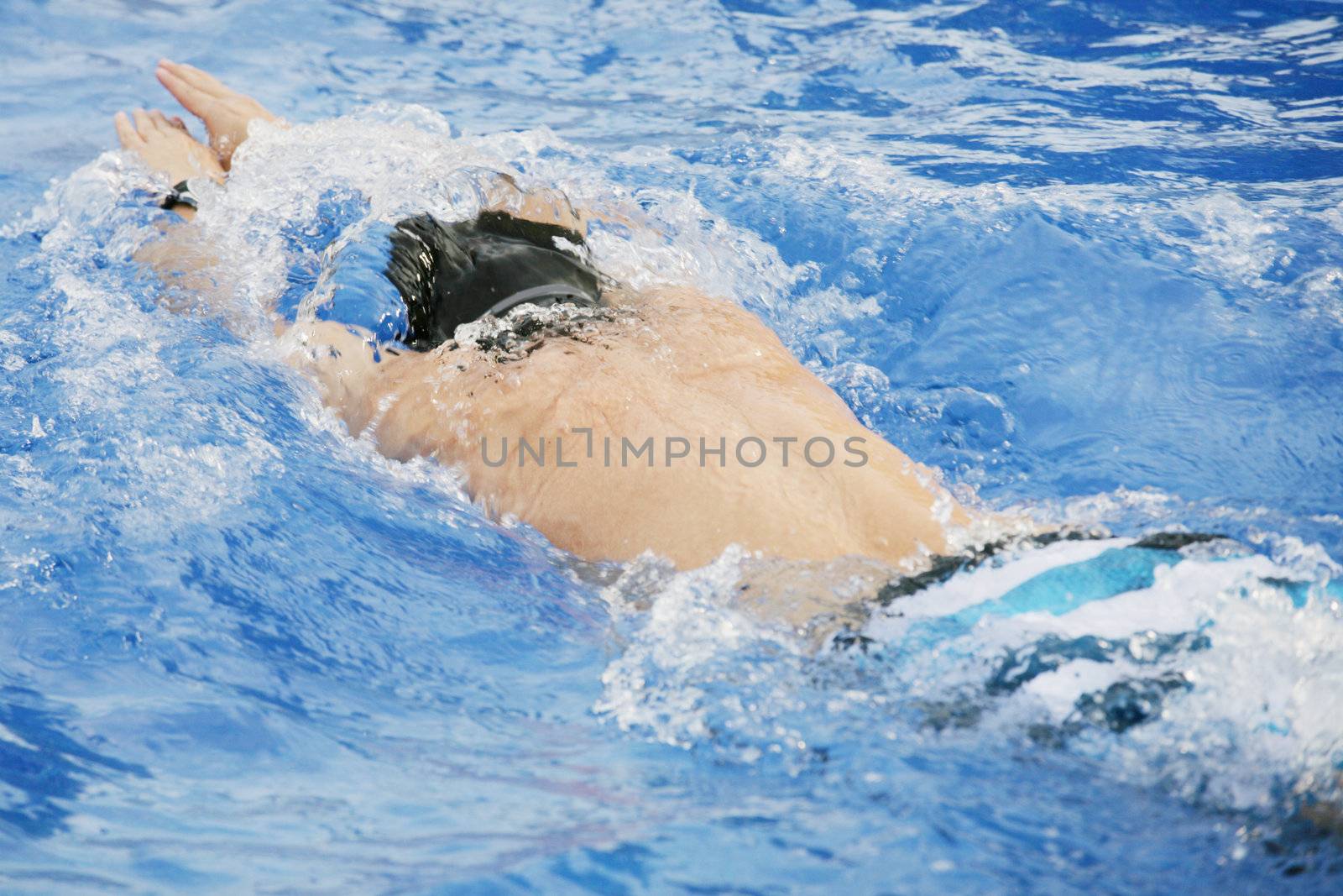 man swims in swimming pool by dacasdo