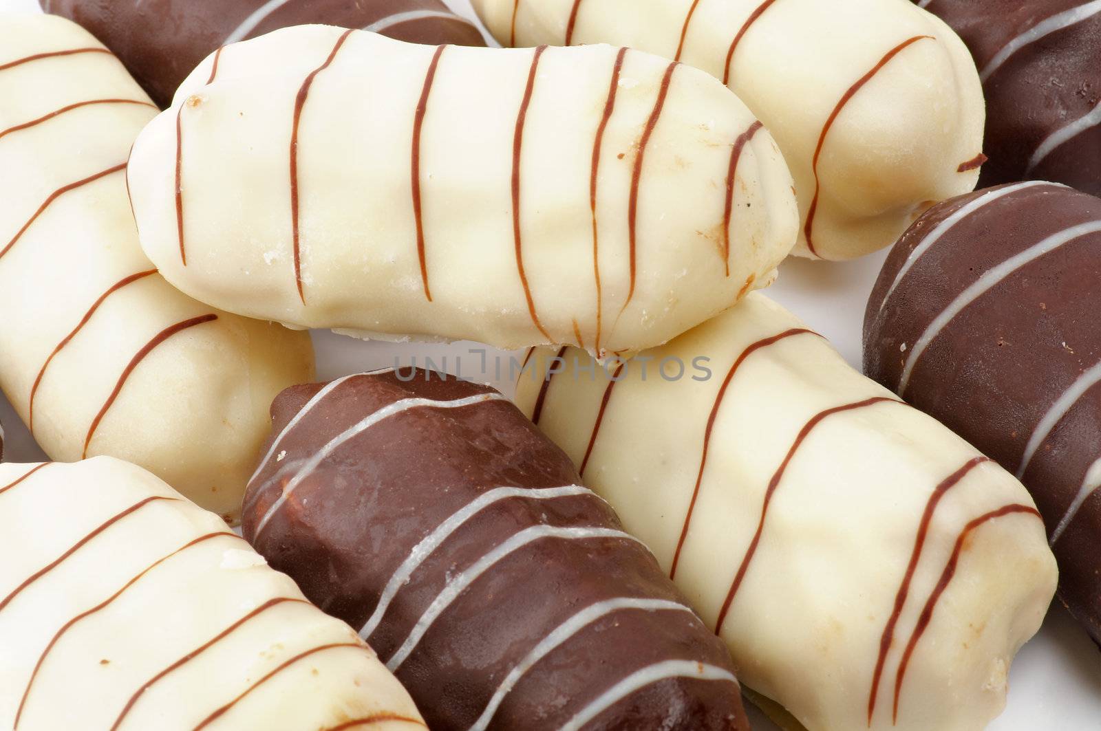 Background of Eclairs with White and Black Chocolate Glaze closeup