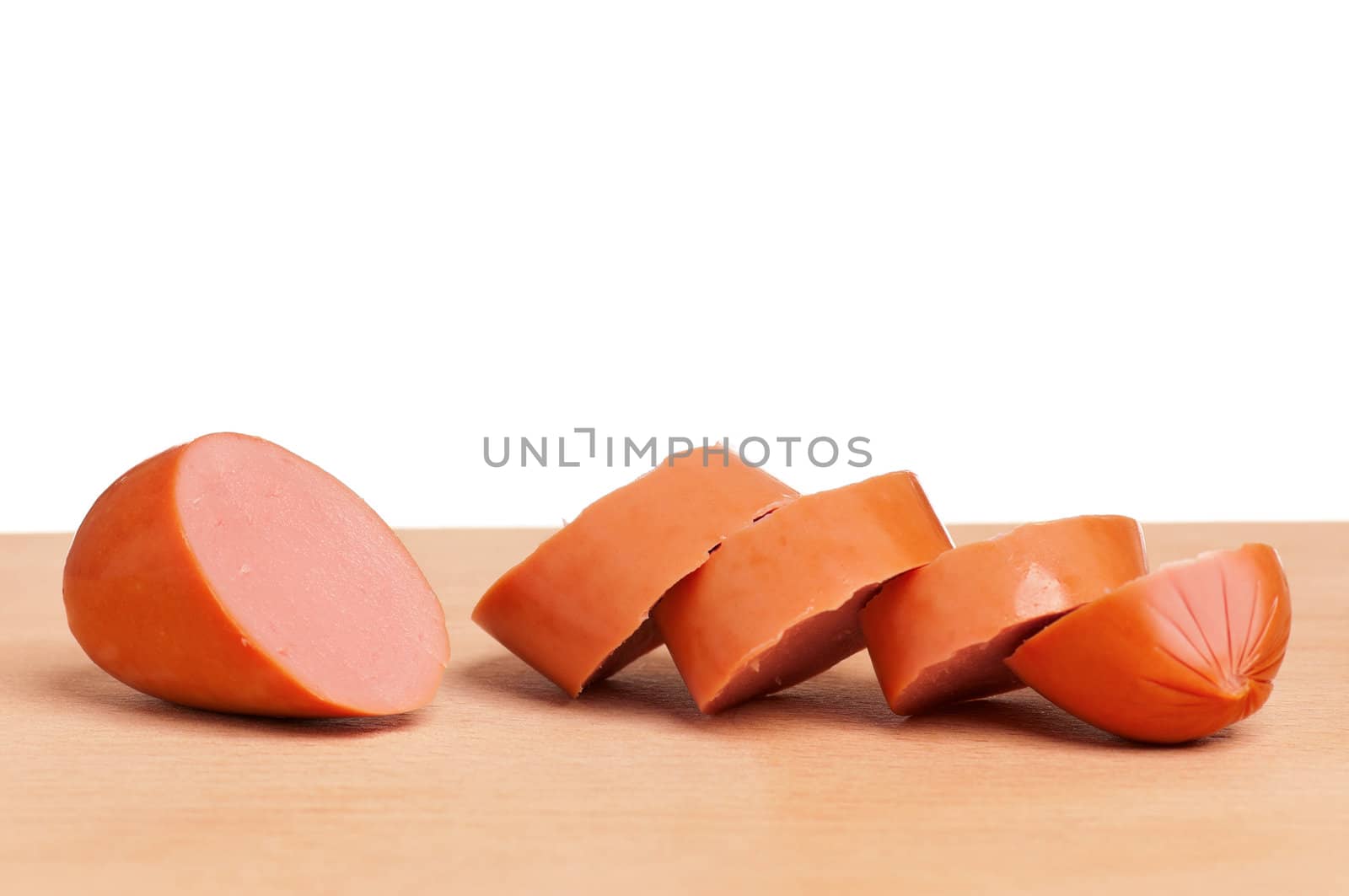 Tasty delicious sausage on wooden table on white background