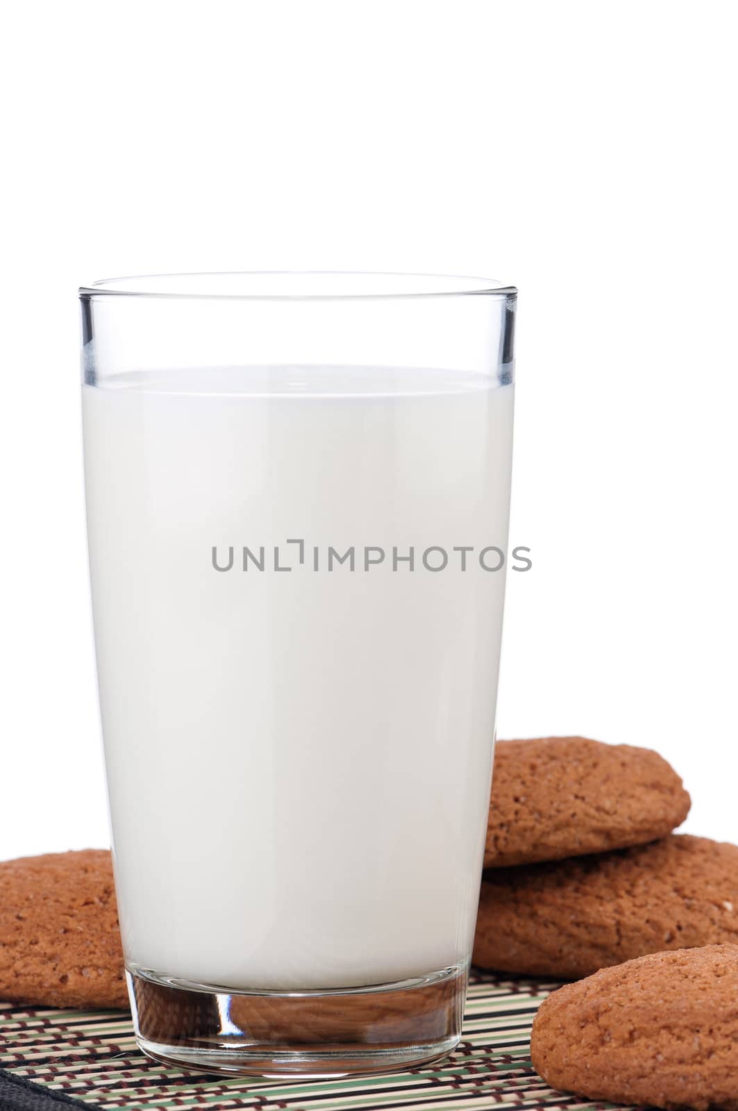 Glass of milk with cookies on white background