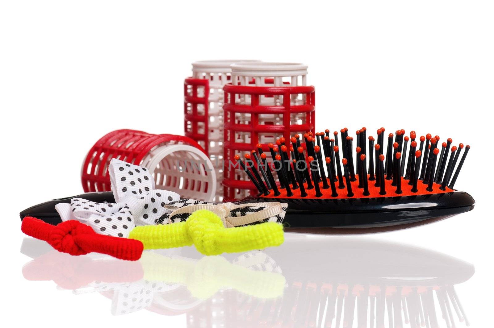 Red hair curlers and hairbrush isolated on white background