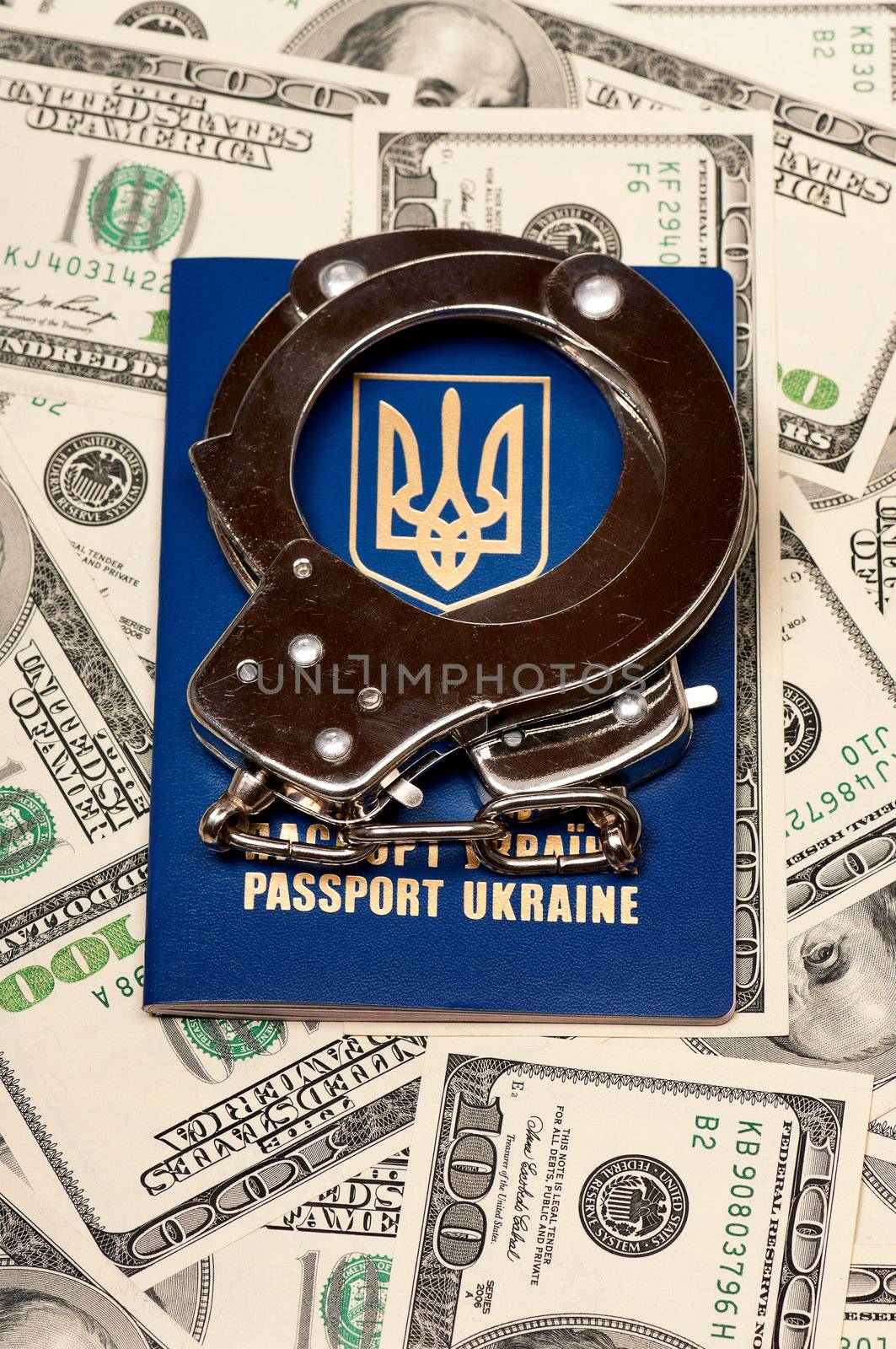 International Ukrainian passport with handcuffs on US dollars background