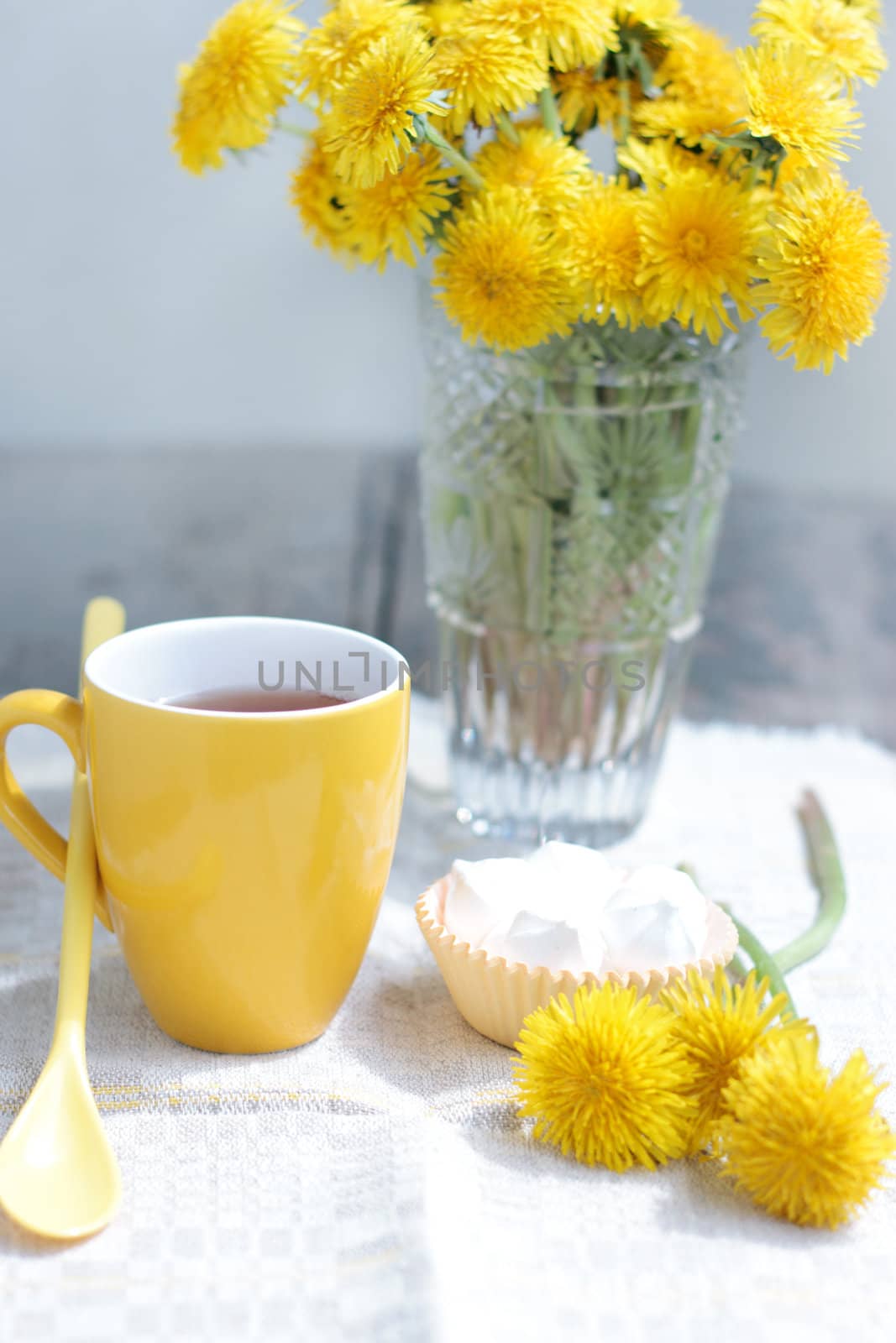 Herbal tea in glass cup and flowers on wooden table