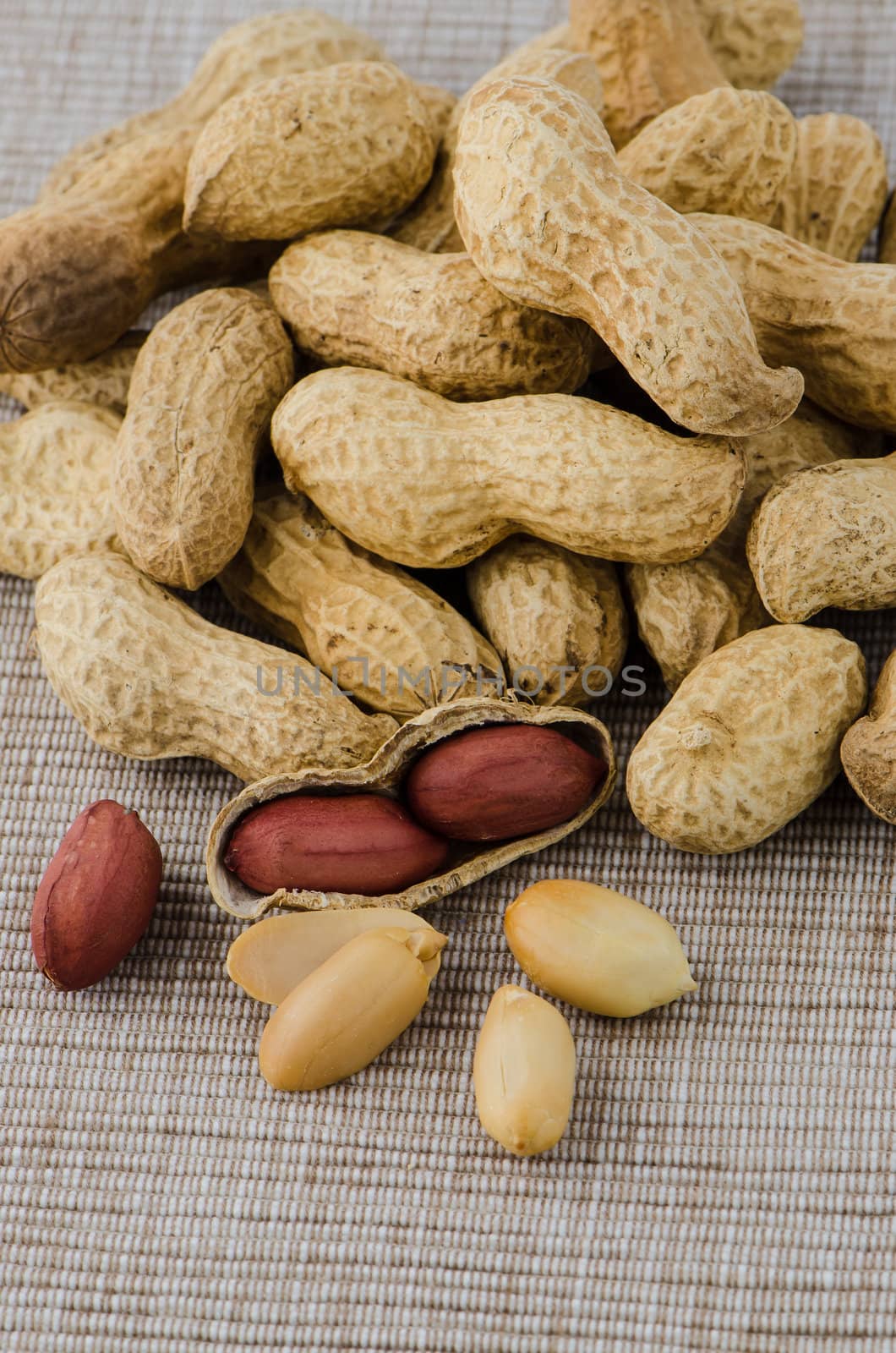 Peanuts on brown textile background.