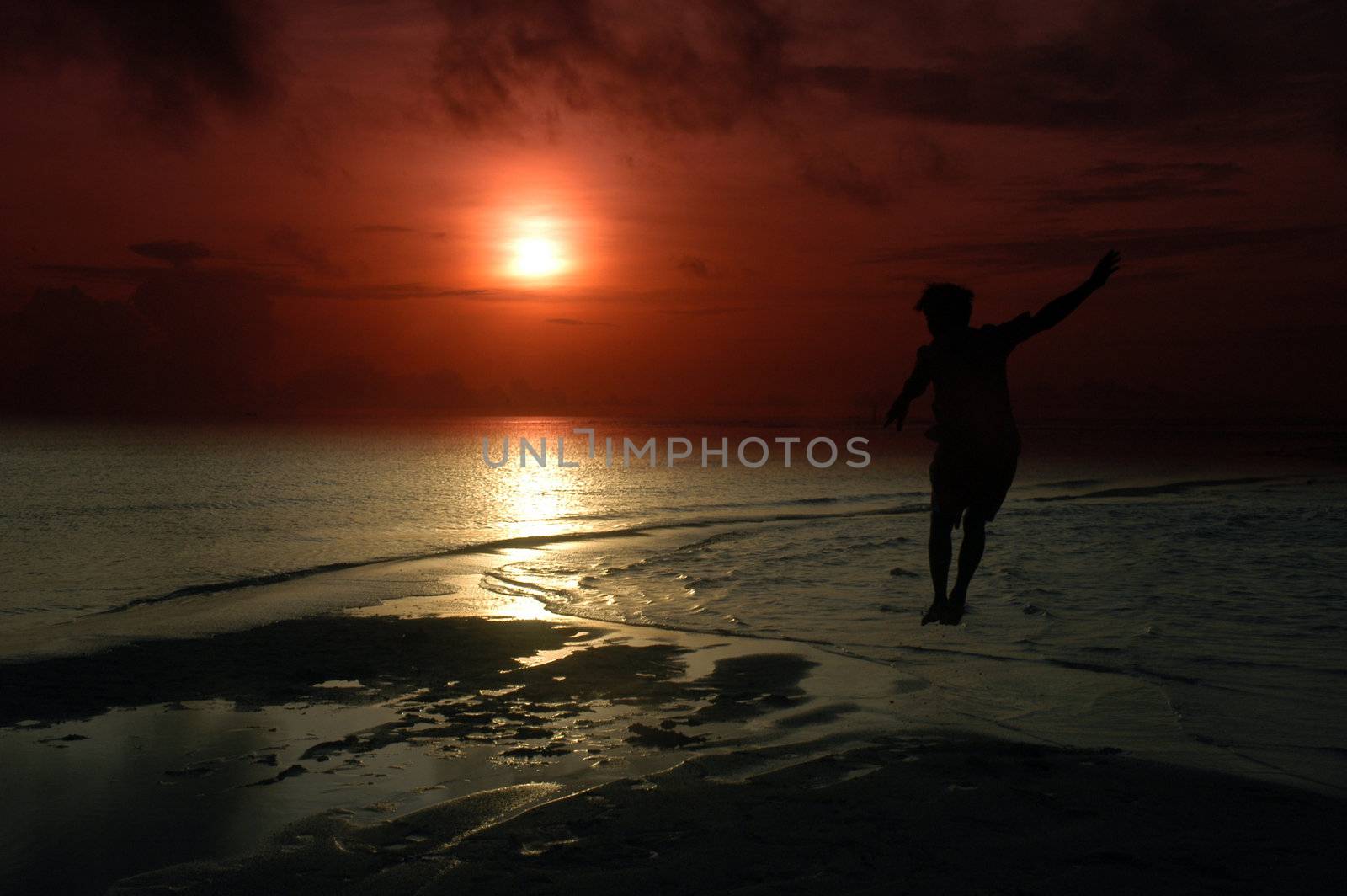 silhouette of a man jumping into the sun by antonihalim