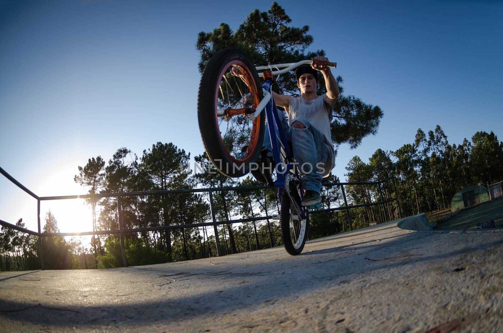 Bmx rider on a ramp over clear sky background.