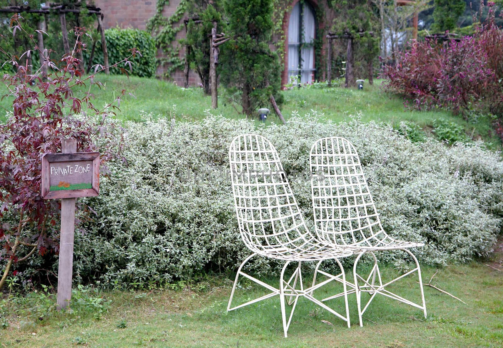 Relax with two white chairs in a garden