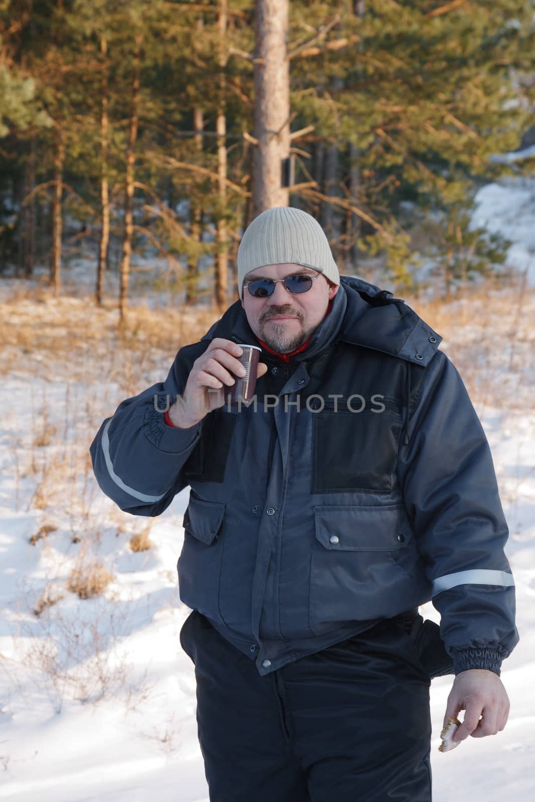 in cold winter day in the forest a man drinking hot tea