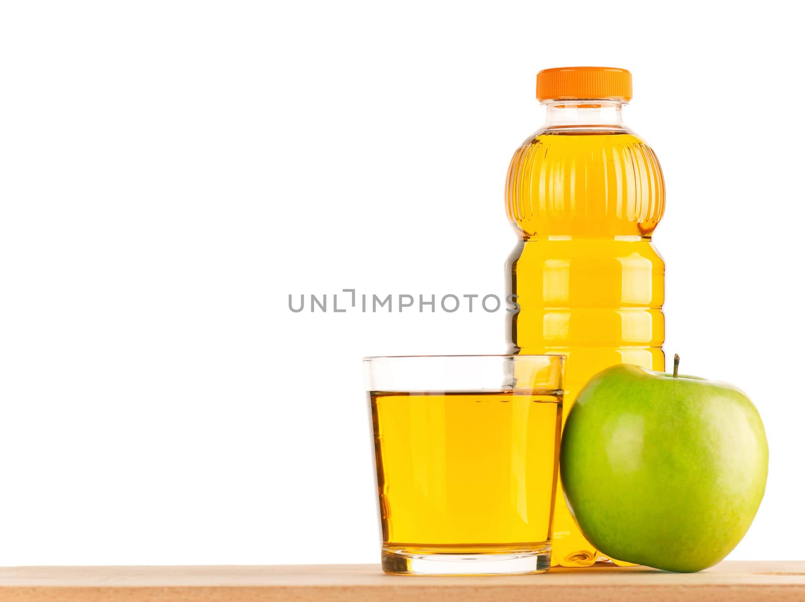 Apple juice in plastic bottle and glass on wooden board over white background