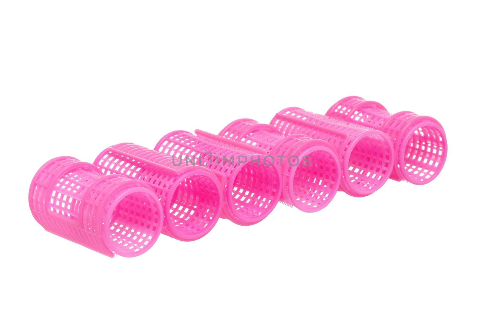 Few pink hair curlers isolated on white background