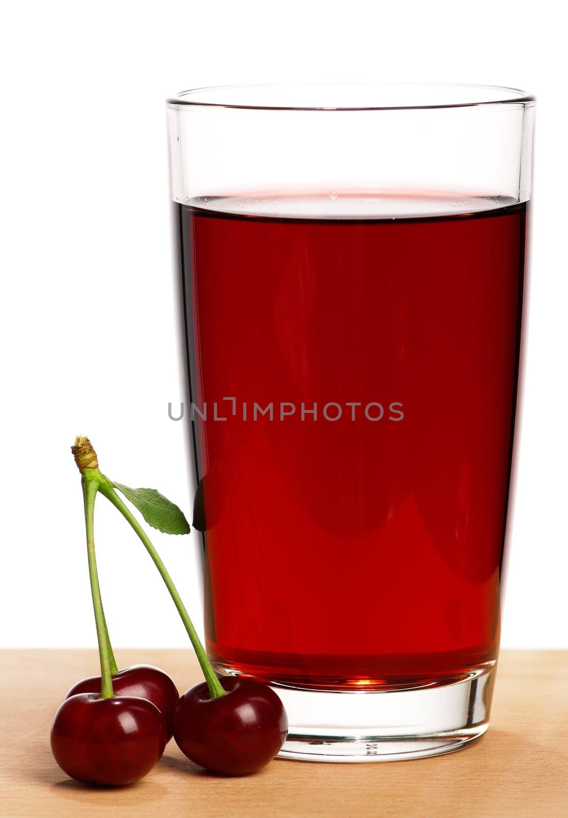 Sweet cherries and glass of juice on a white background