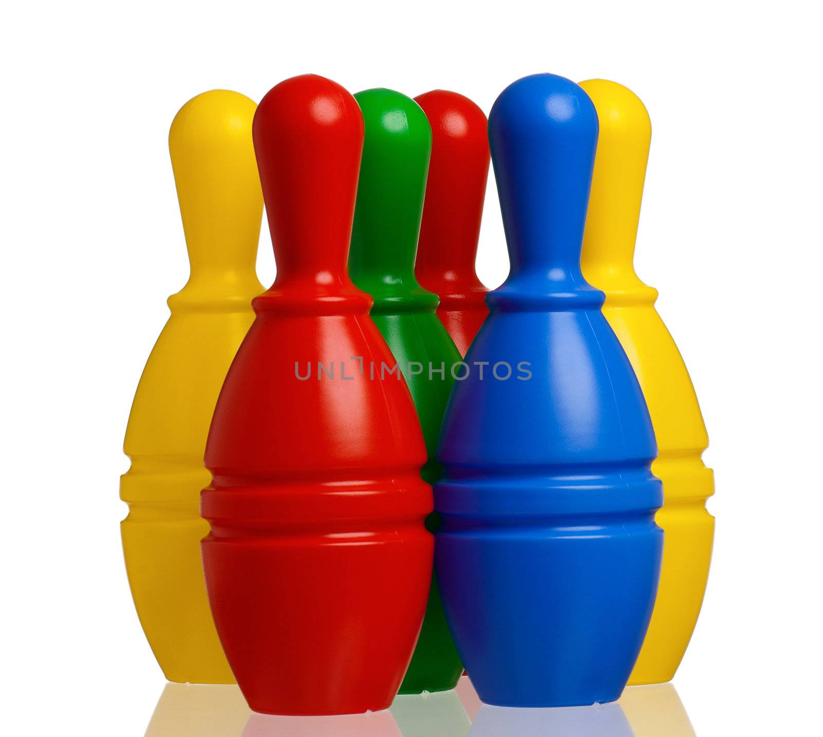 Colorful plastic skittles of toy bowling with orange ball isolated on a white background