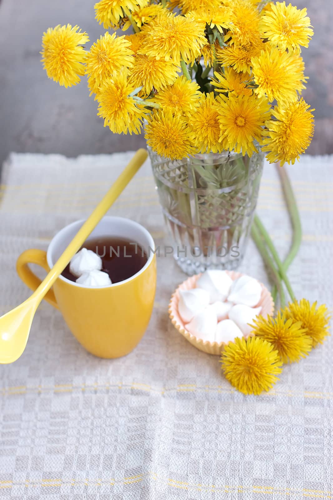 Herbal tea in glass cup and flowers on wooden table