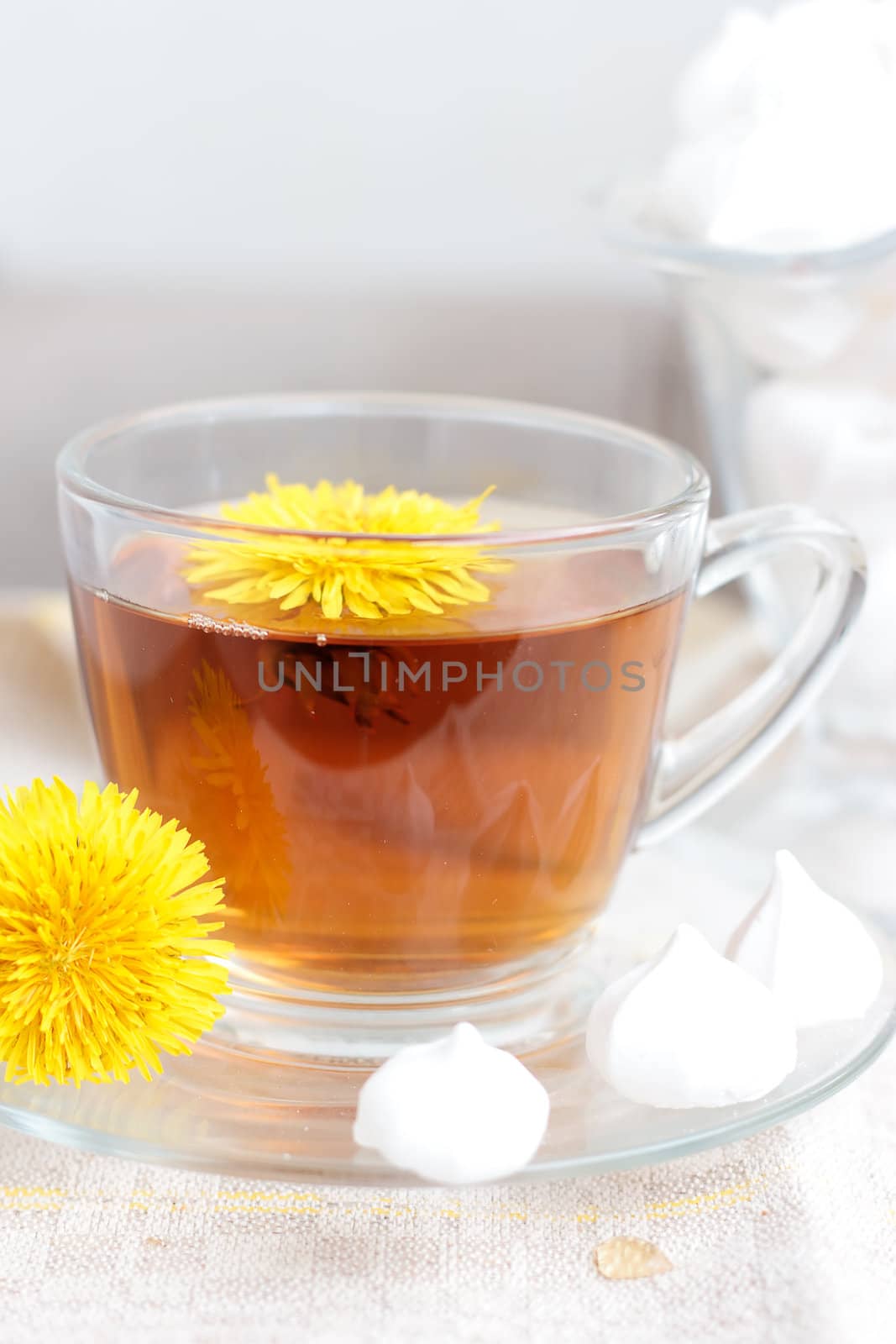 Herbal tea in glass cup and flowers on wooden table