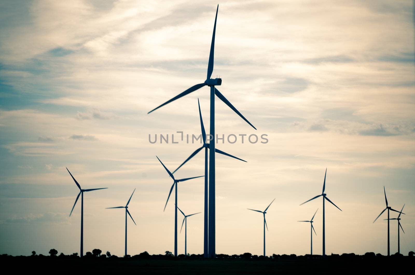 Backlit view of a group of mills for electric power generation