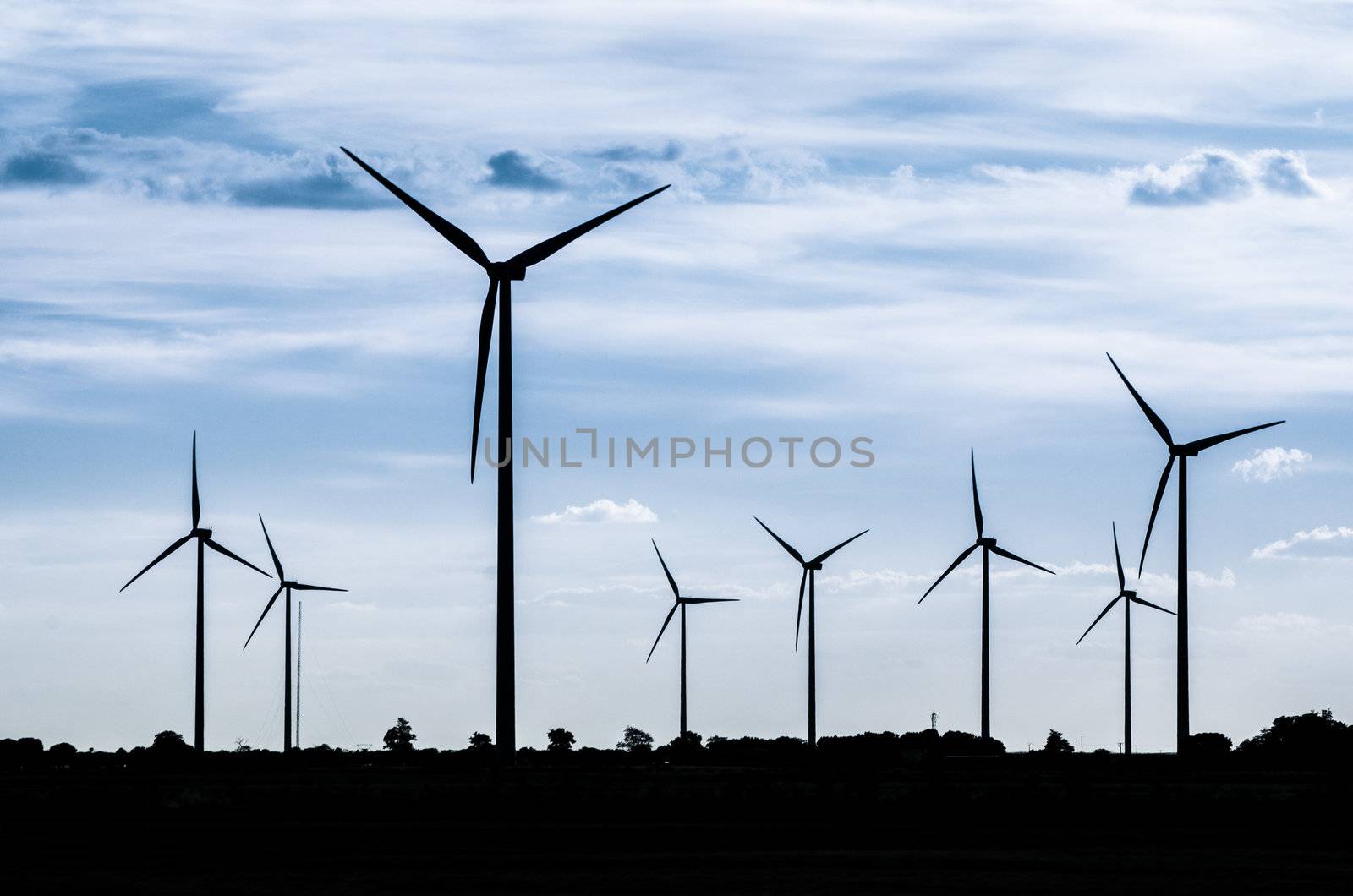 Backlit view of a group of mills for electric power generation