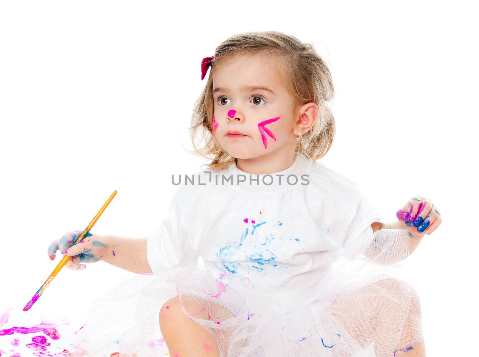 Beautiful little girl with a brush and paints