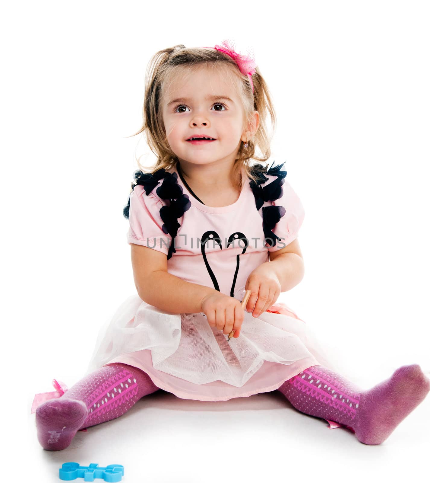 Portrait of a cute little girl sitting on floor, isolated over white