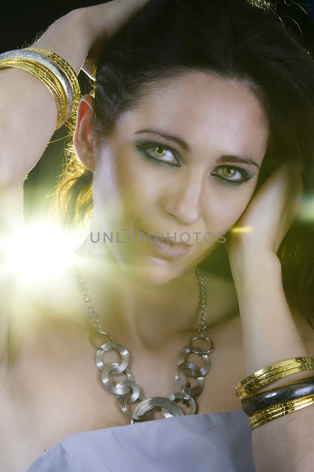 Beautiful woman with evening make-up. Jewelry and Beauty. Yellow light