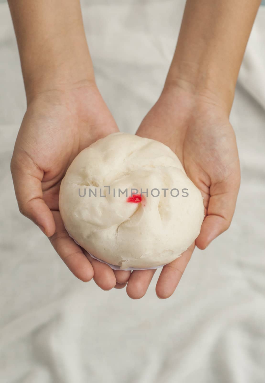Hand giving a bun by TanawatPontchour