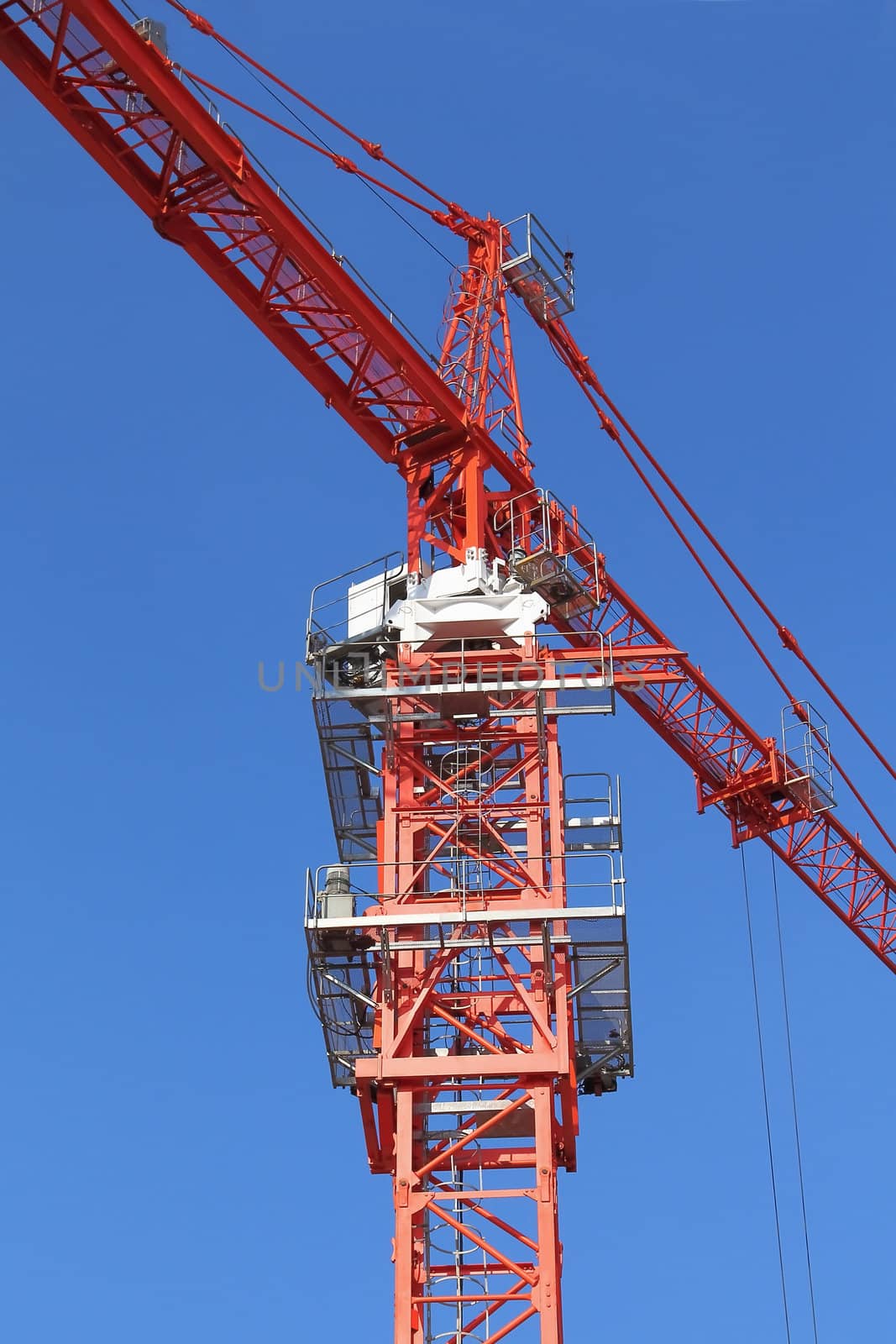 Red building crane on blue sky