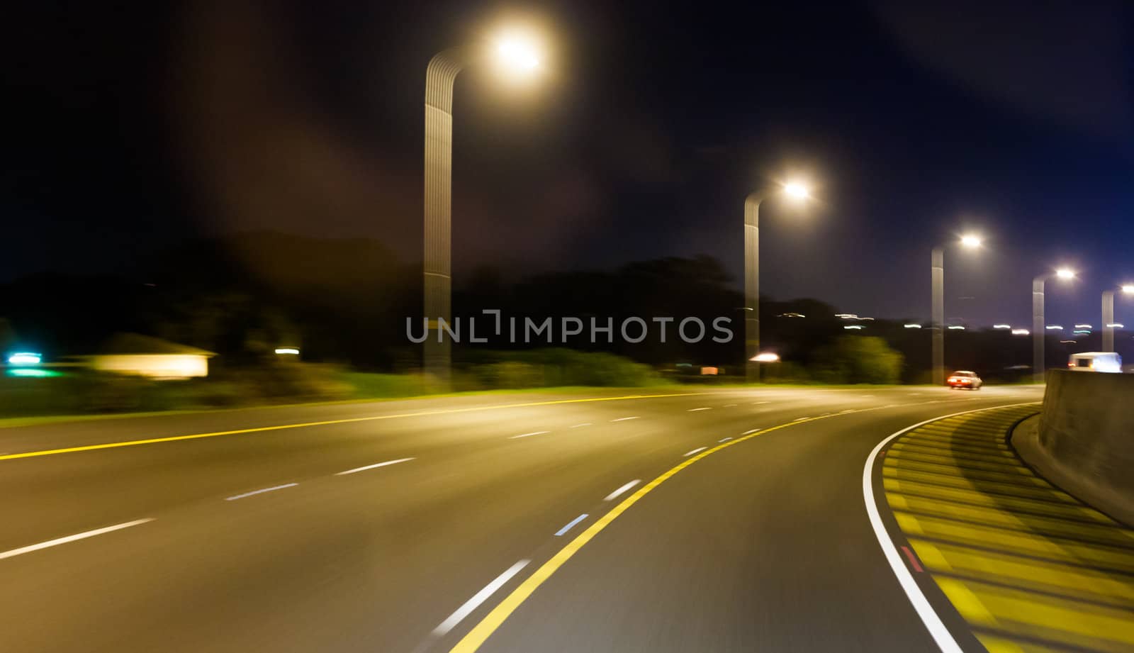 Highway speed blur at dusk with street lights