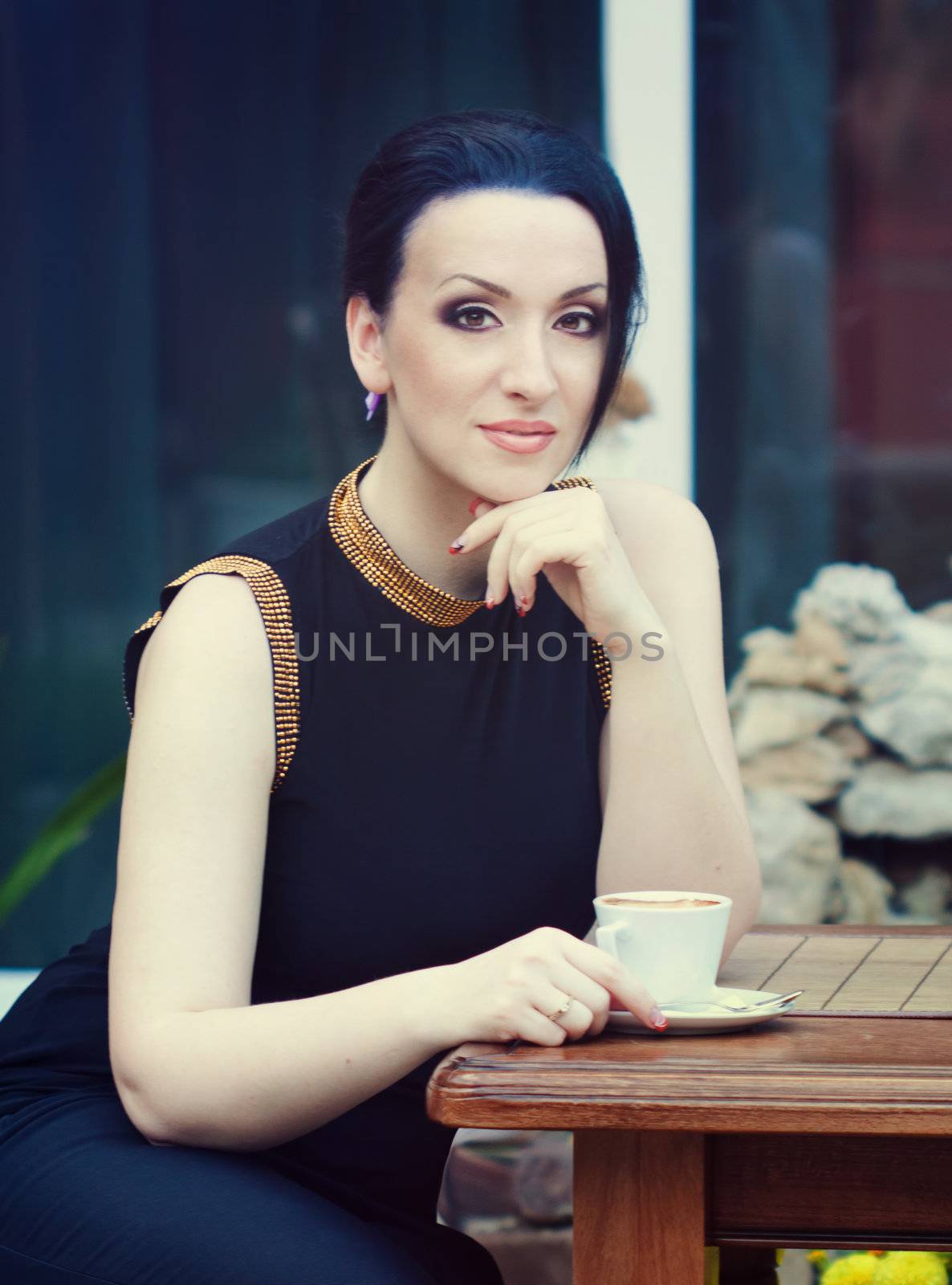 beautiful brunnette drinking coffee in a restaurant outdoor