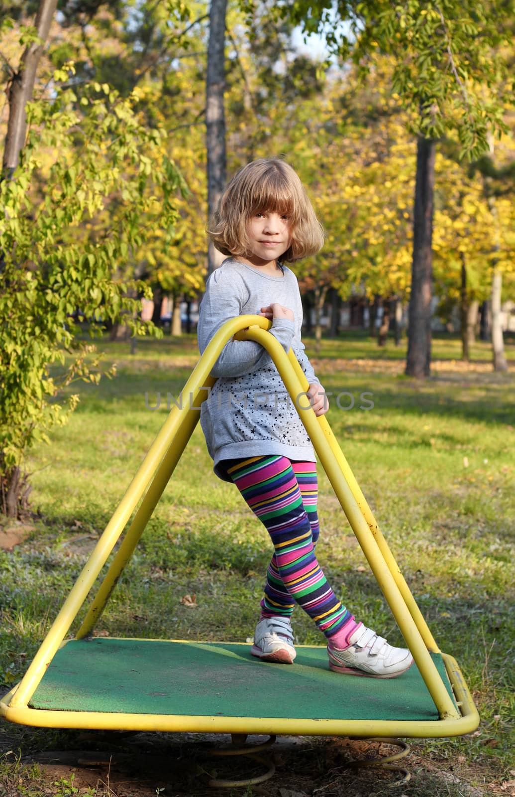 beautiful little girl posing on playground by goce