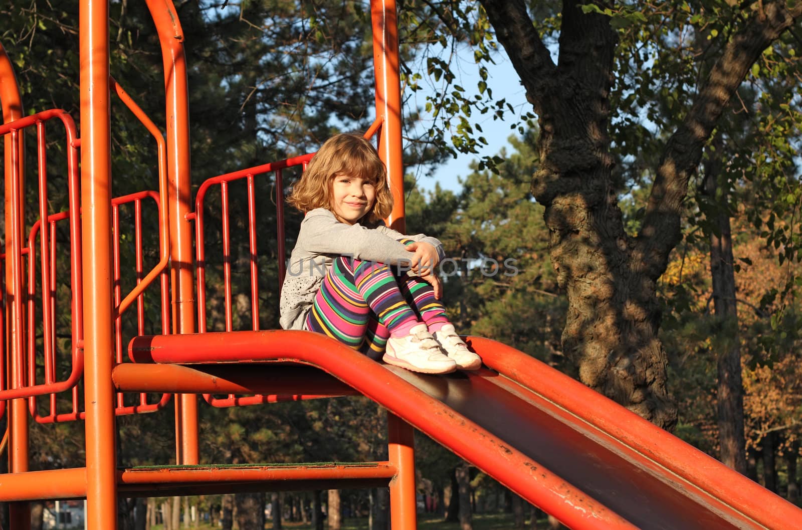 little girl sitting on slide