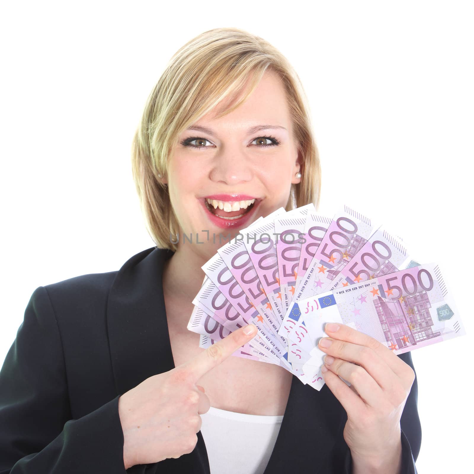 Gleeful young woman pointing to a fistful of 500 euro notes which she is holding fanned in her hand isolated on white