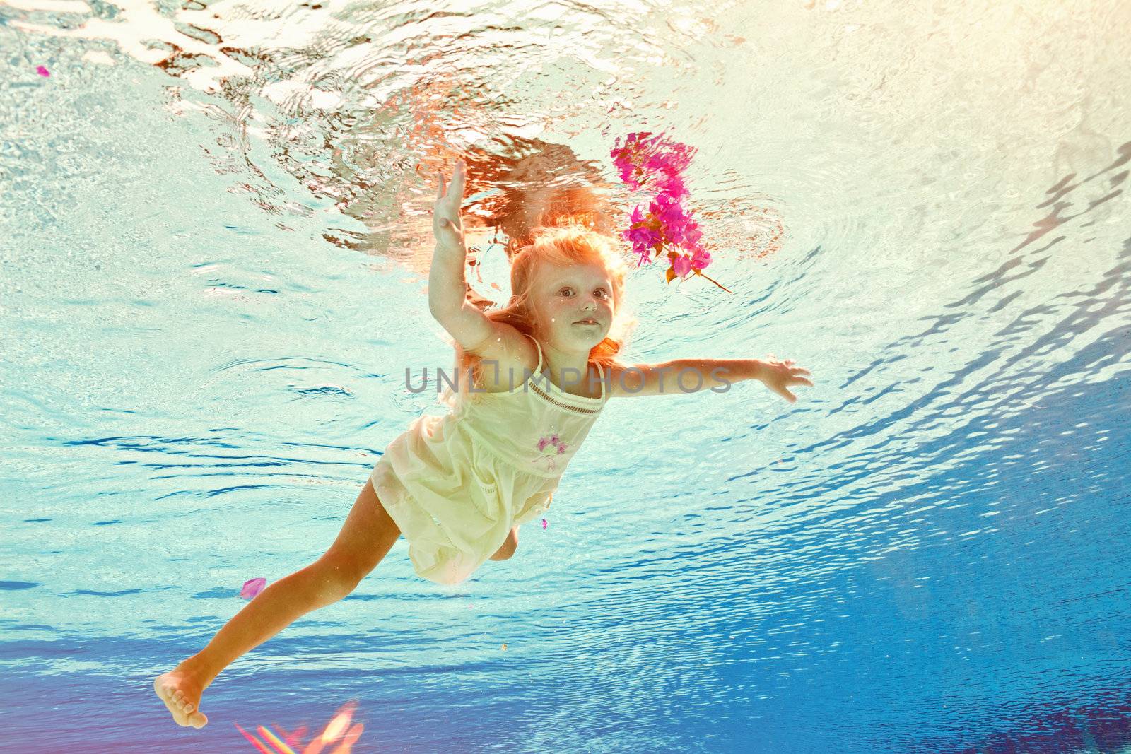 girl in the swimming-pool under water with a flower