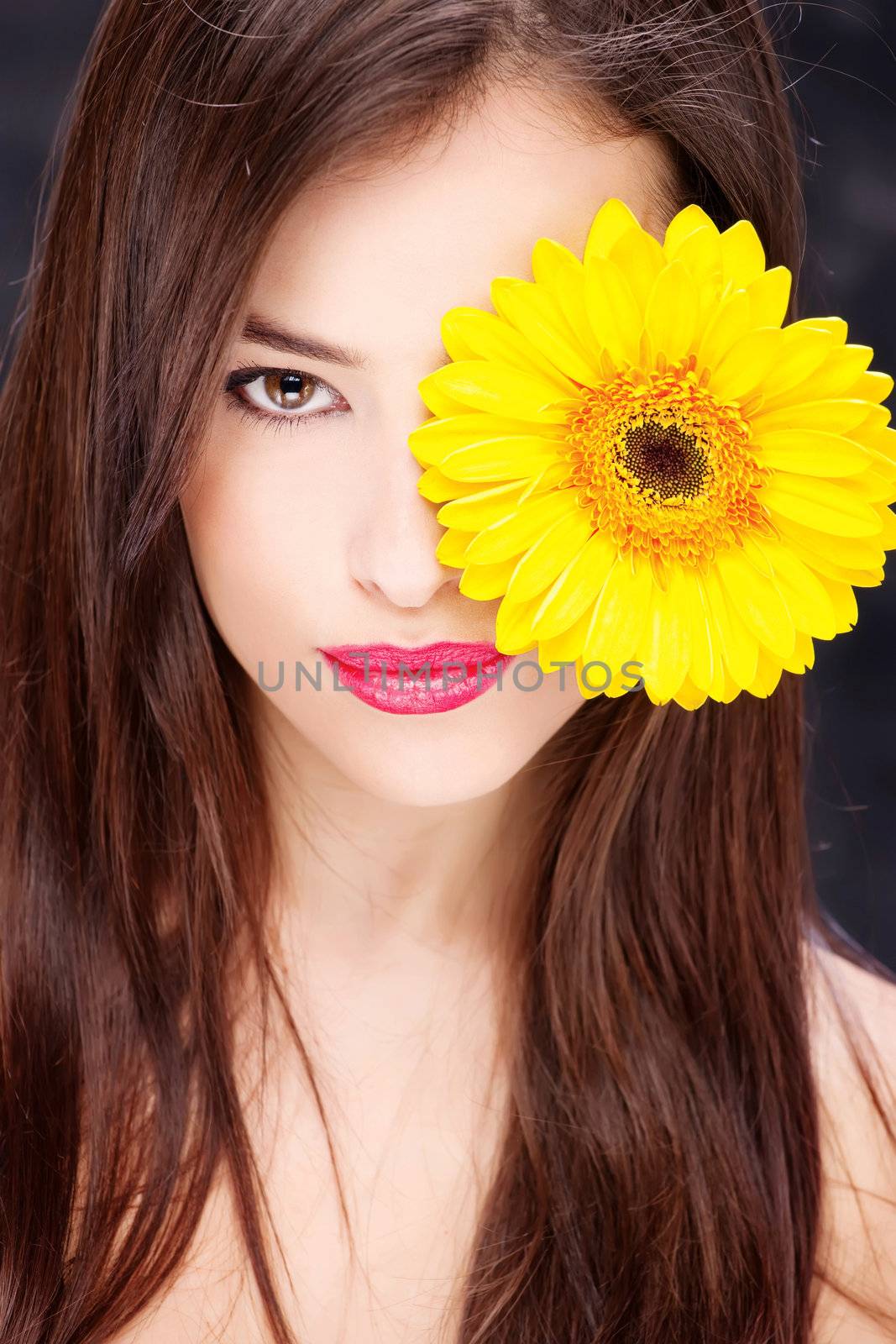 Yellow daisy over pretty woman's eye
