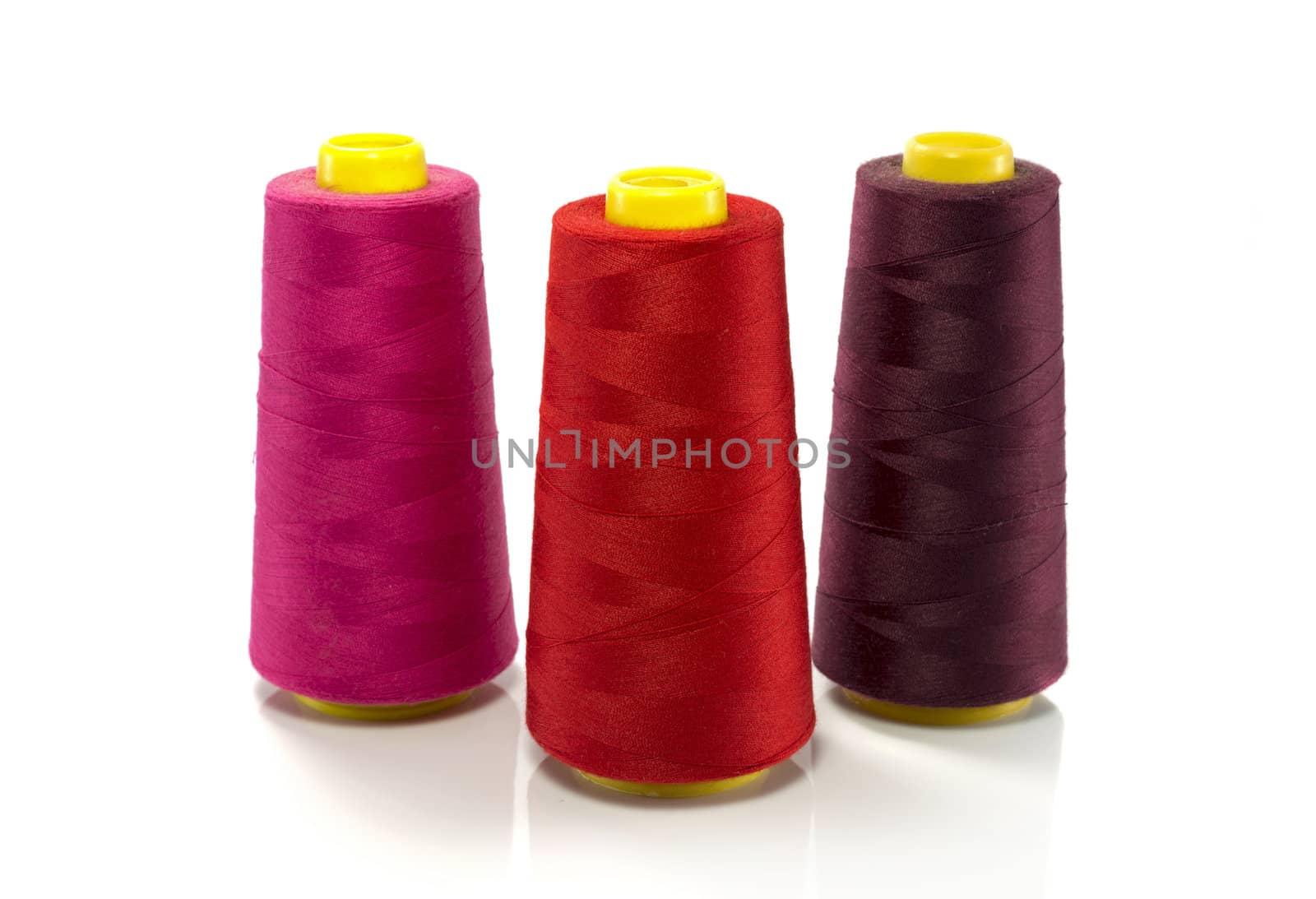 red pink and purple bobbin with thread  isolated on white