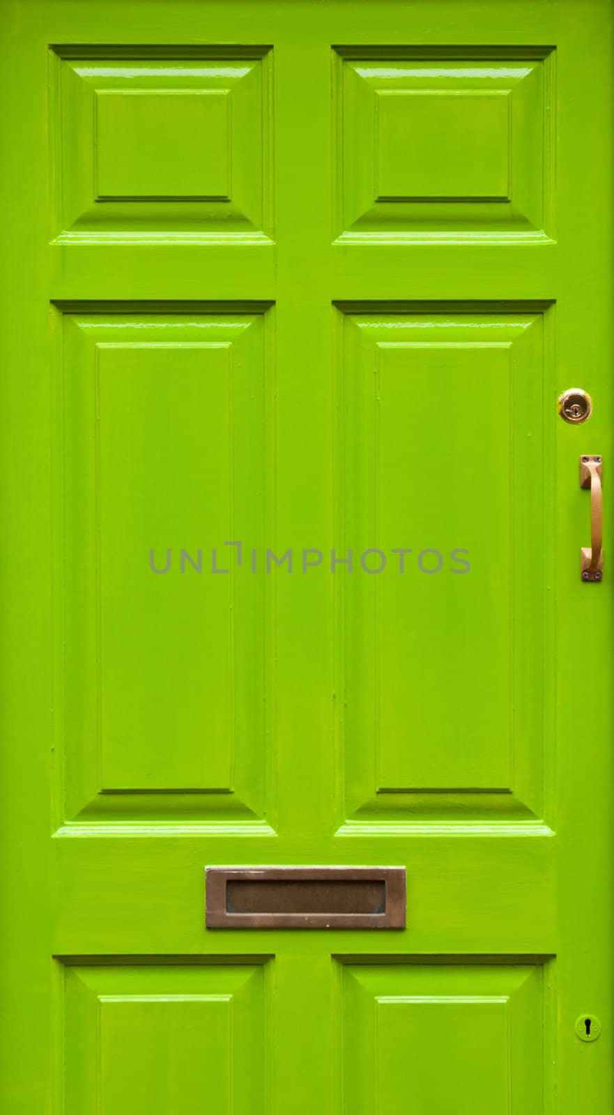 green typical residential house door in Ireland (golden lock, handle and mailbox)