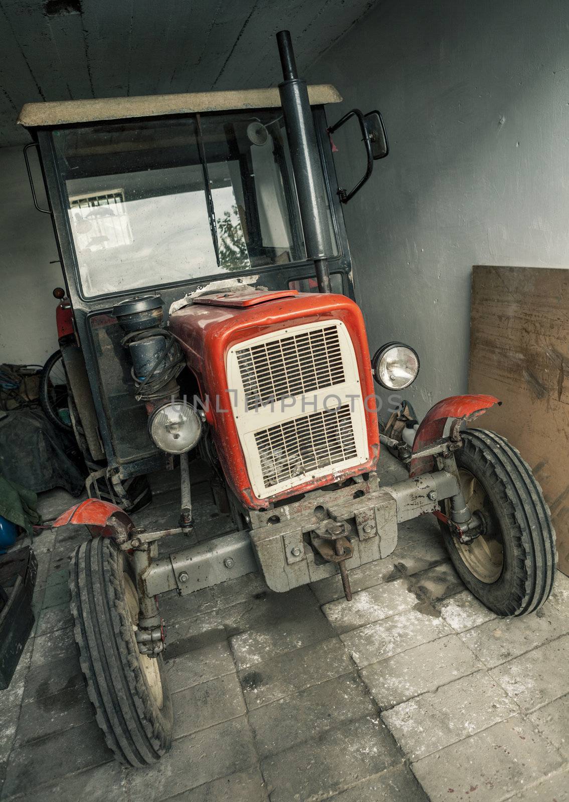 Old rusty tractor in a garage.