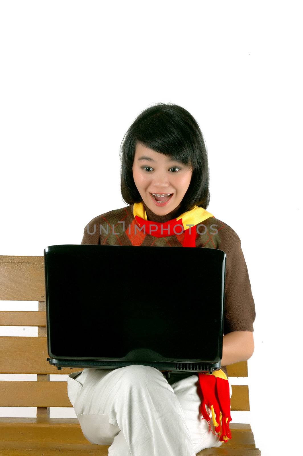 young woman surprised looking into laptop isolated on white background
