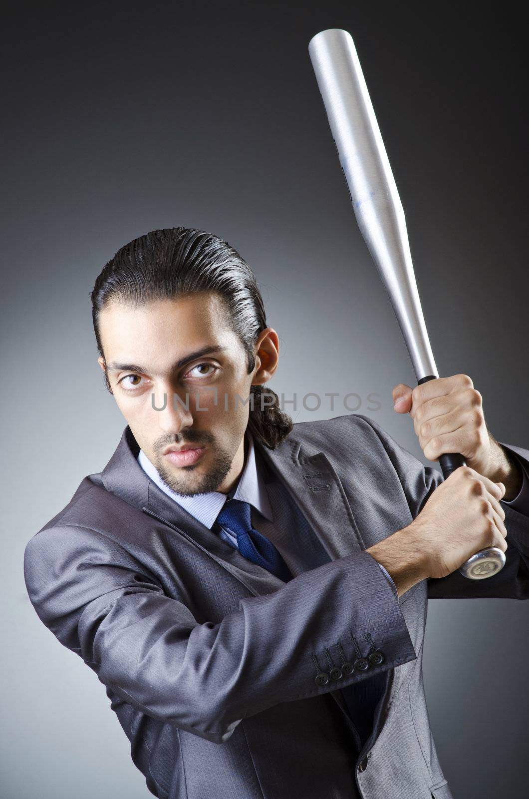 Angry businessman with bat on white