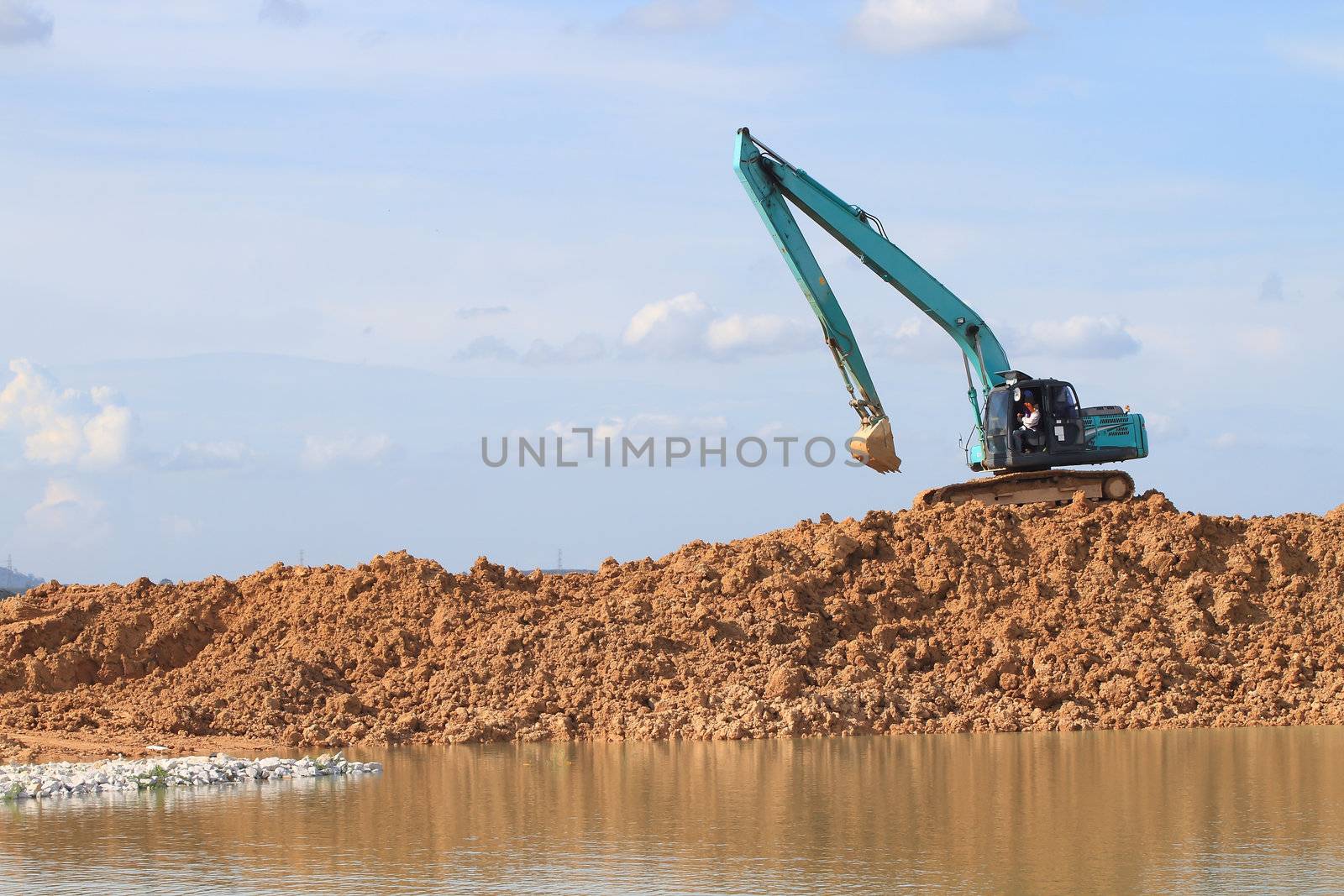 Excavator located by a river and ready for work