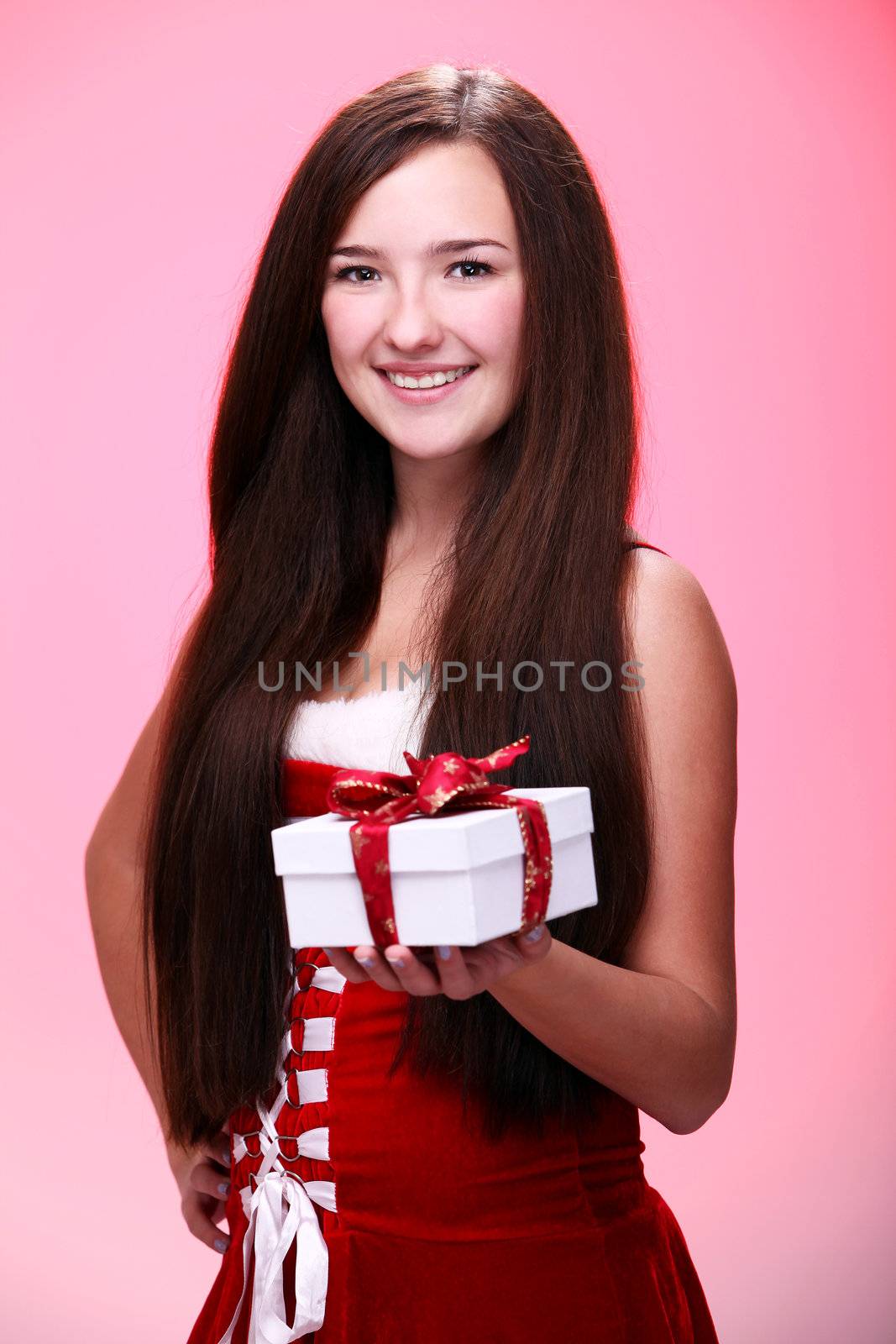 Portrait of young and beautiful christmas girl in red with gift