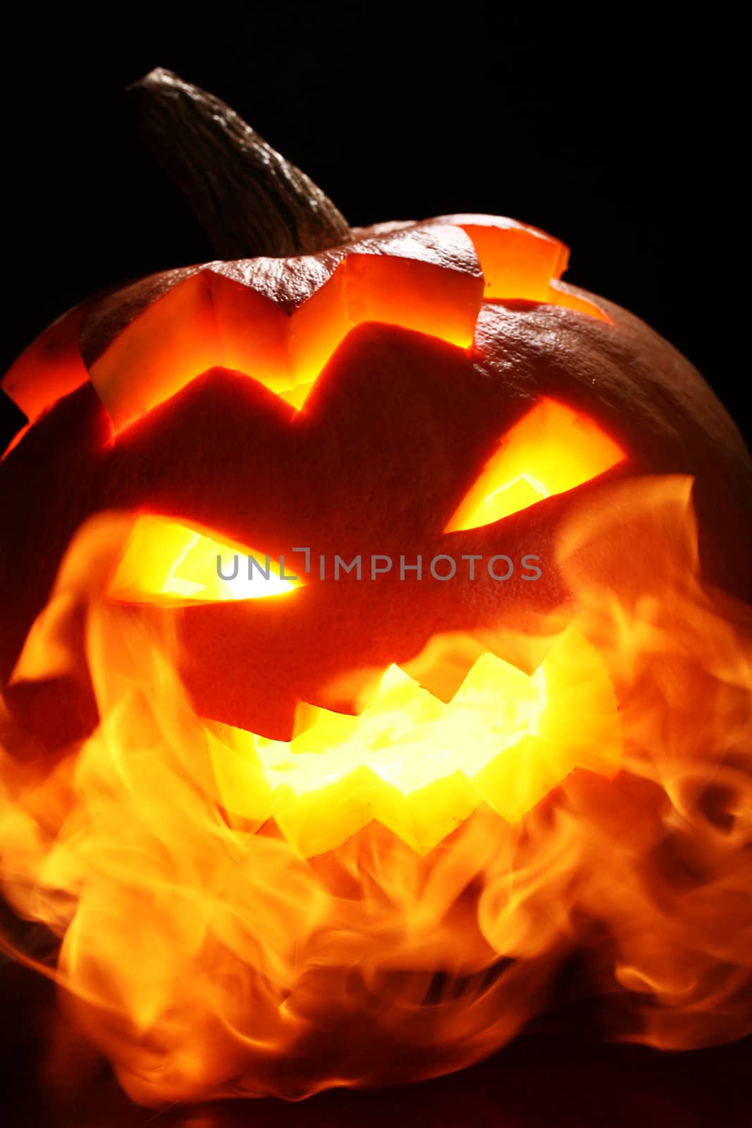 halloween pumpkin in fire over a black background