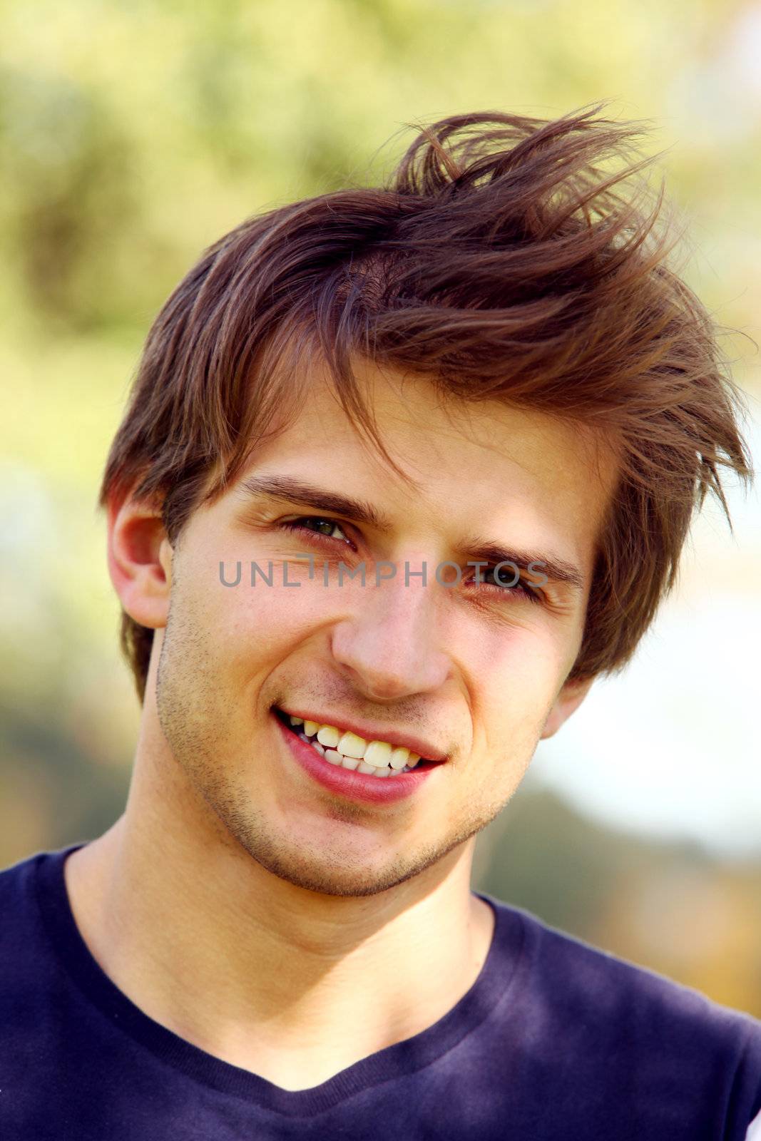 Portrait of young and smiling cute man in park