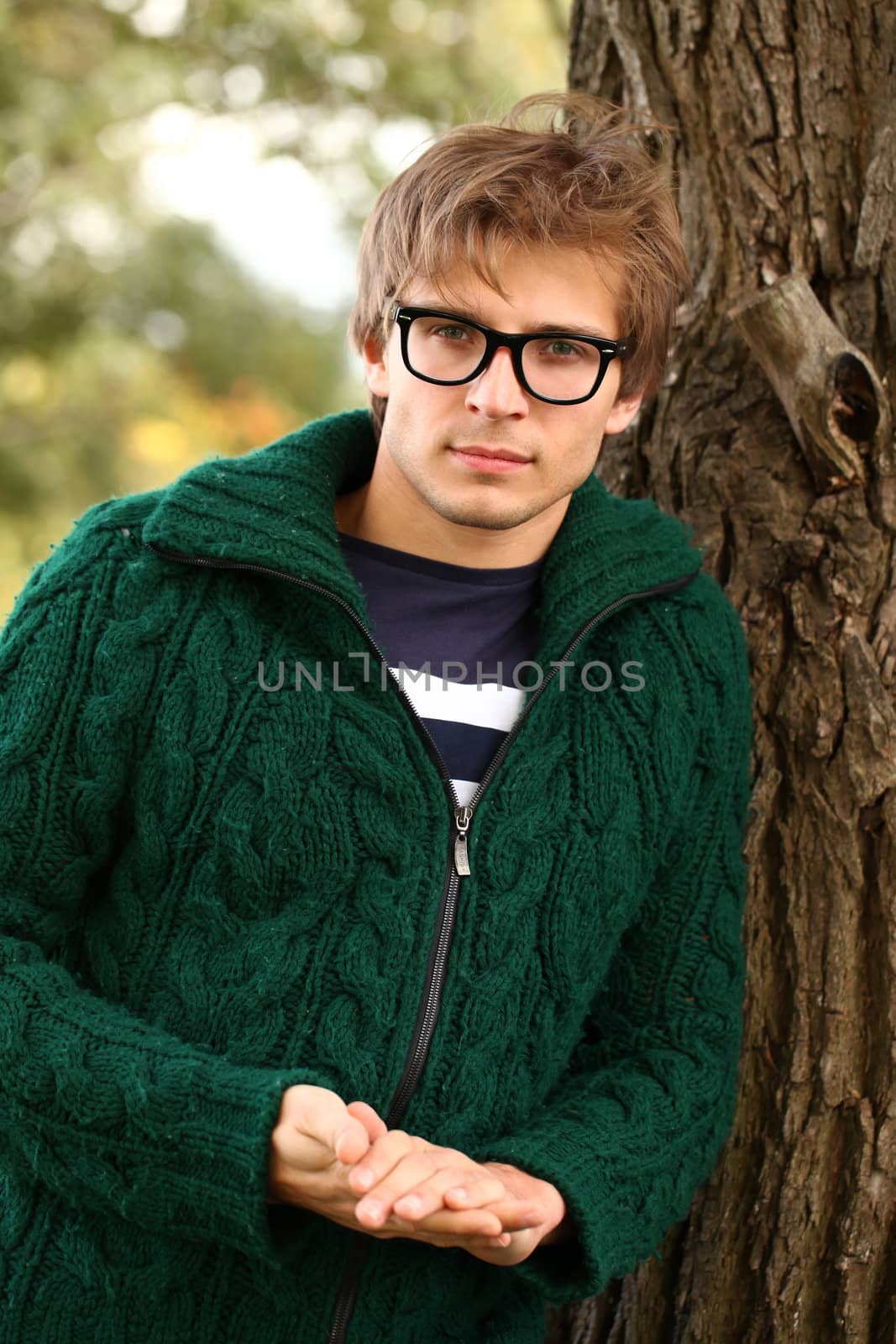 Potrait of handsome and cute guy at cold autumn day in the park