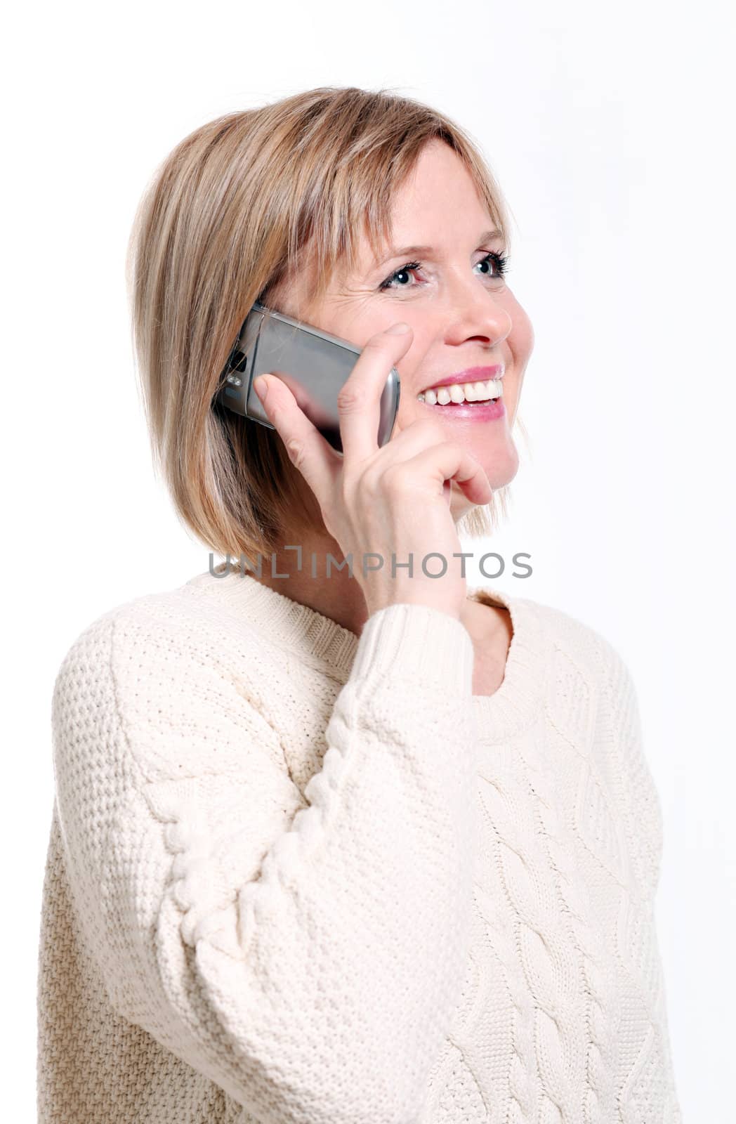 Caucasian middle aged woman on cellphone smiling over white background