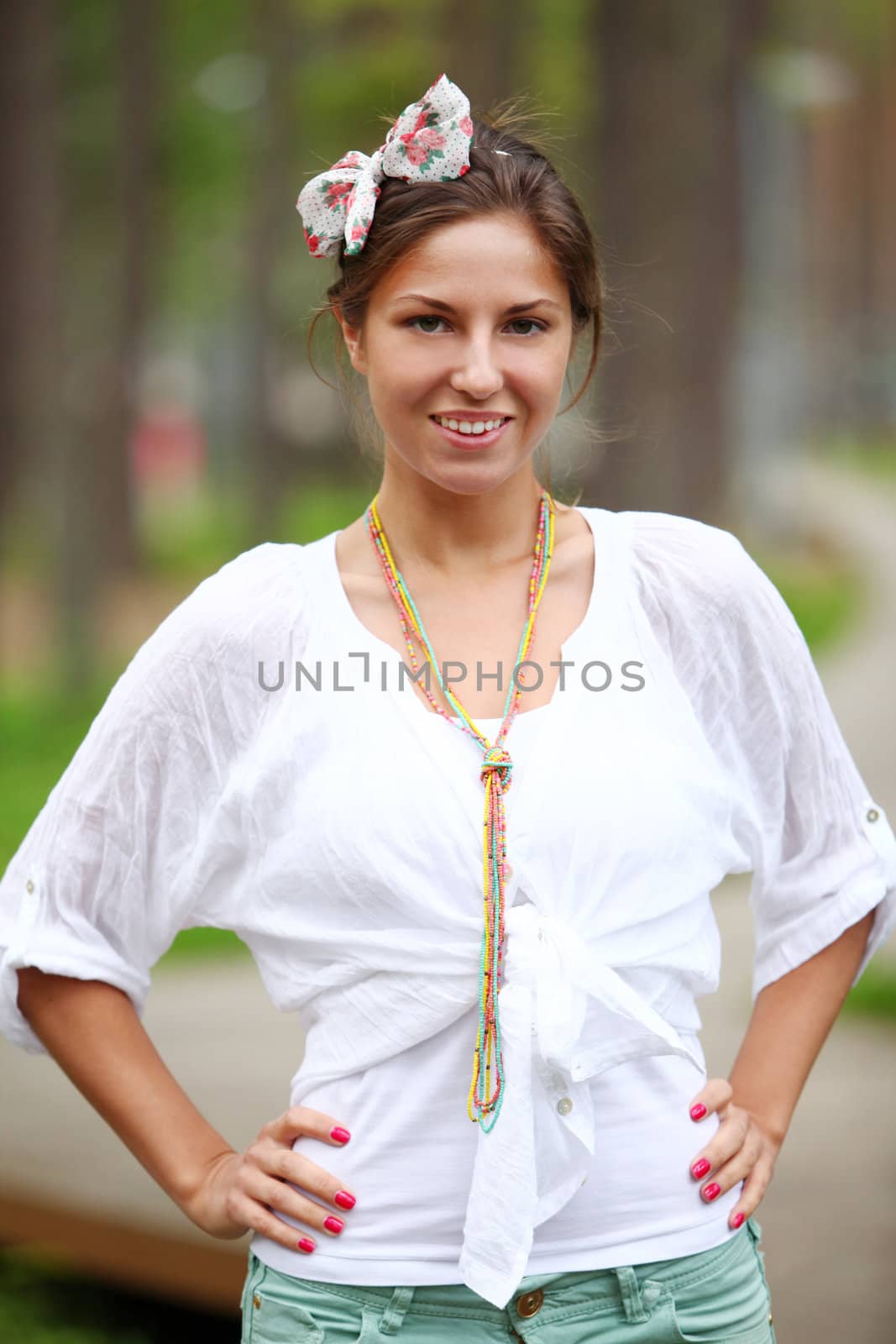 Young smiling woman standing in park by rufatjumali