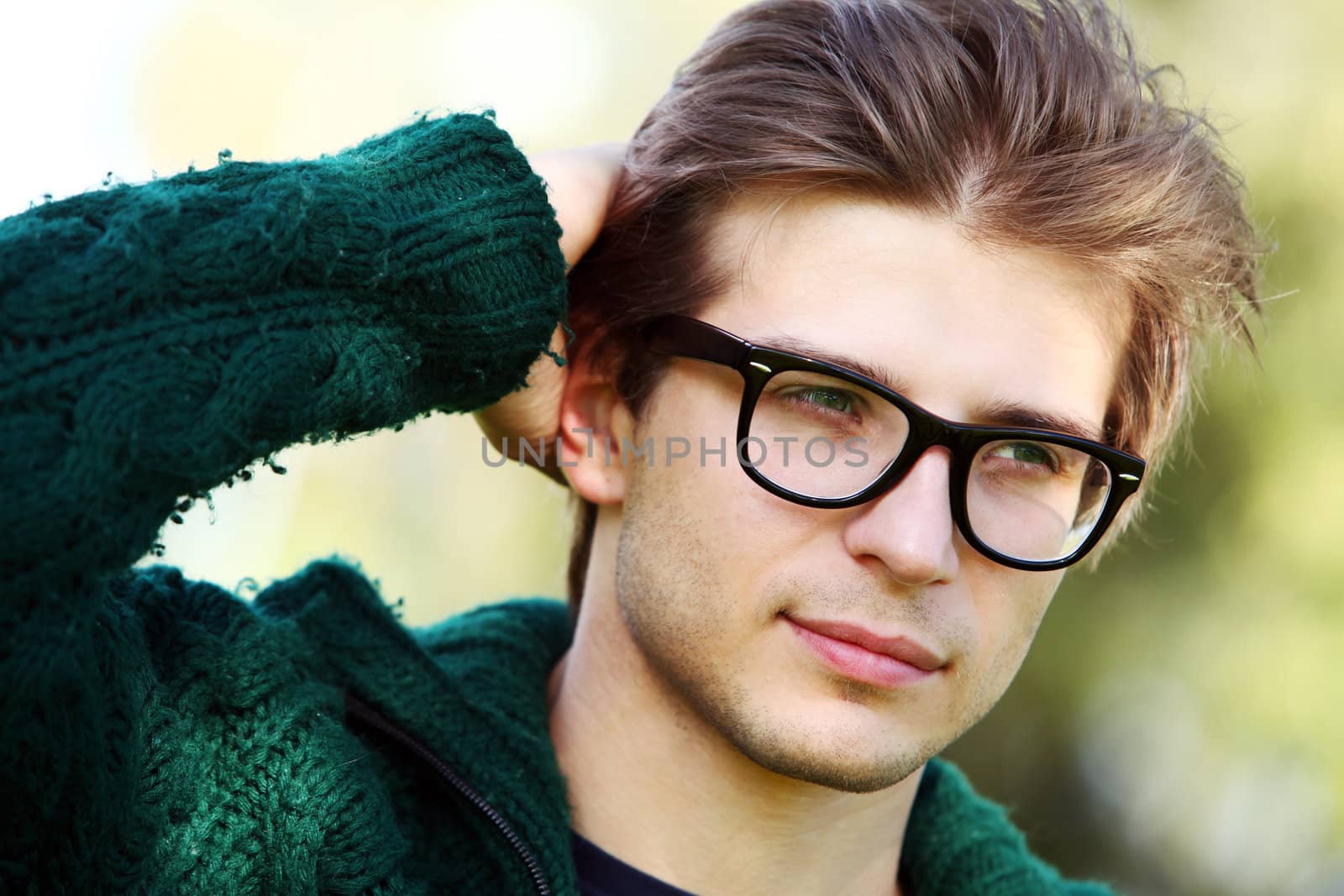 Potrait of handsome and smart guy at cold autumn day in the park