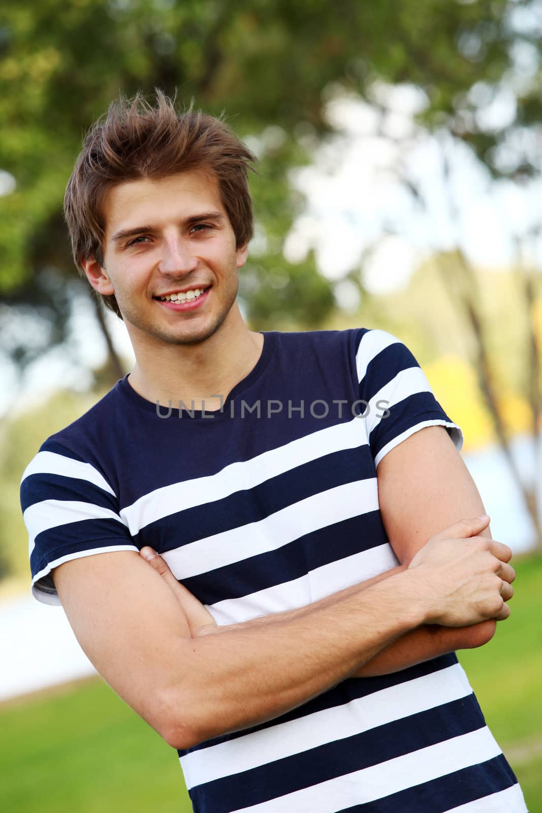 Portrait of young and smiling cute man in park