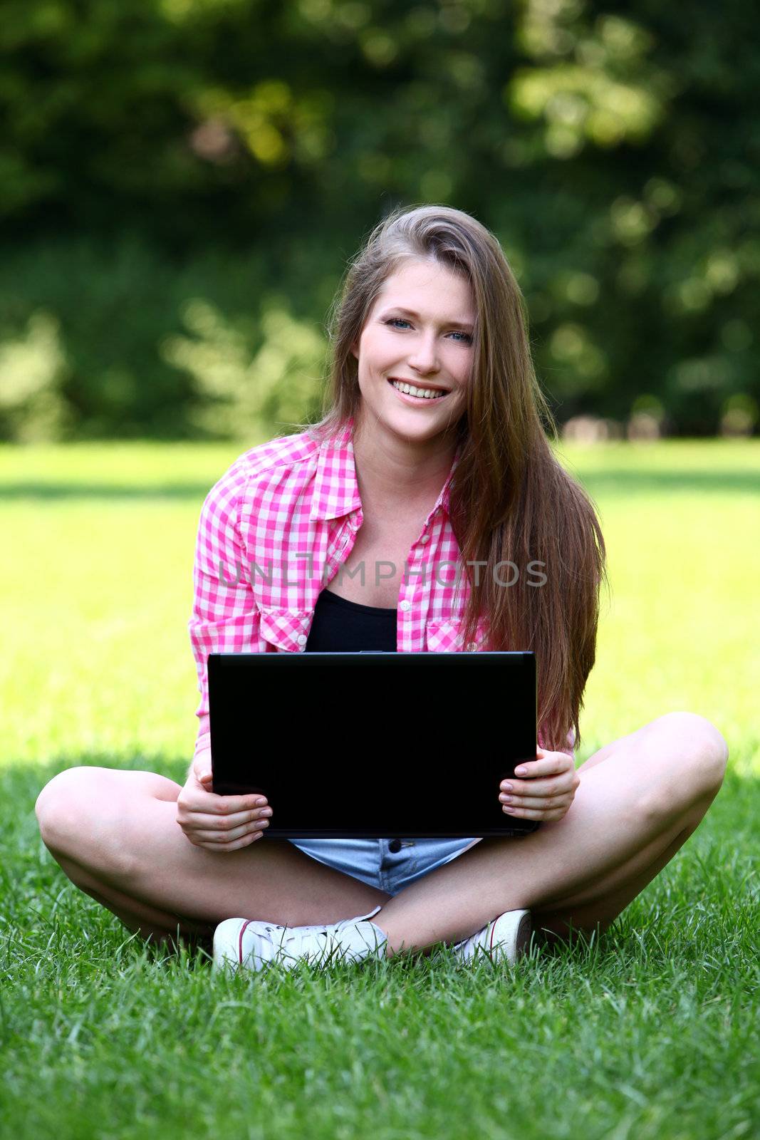 Beautiful woman with laptop in park by rufatjumali