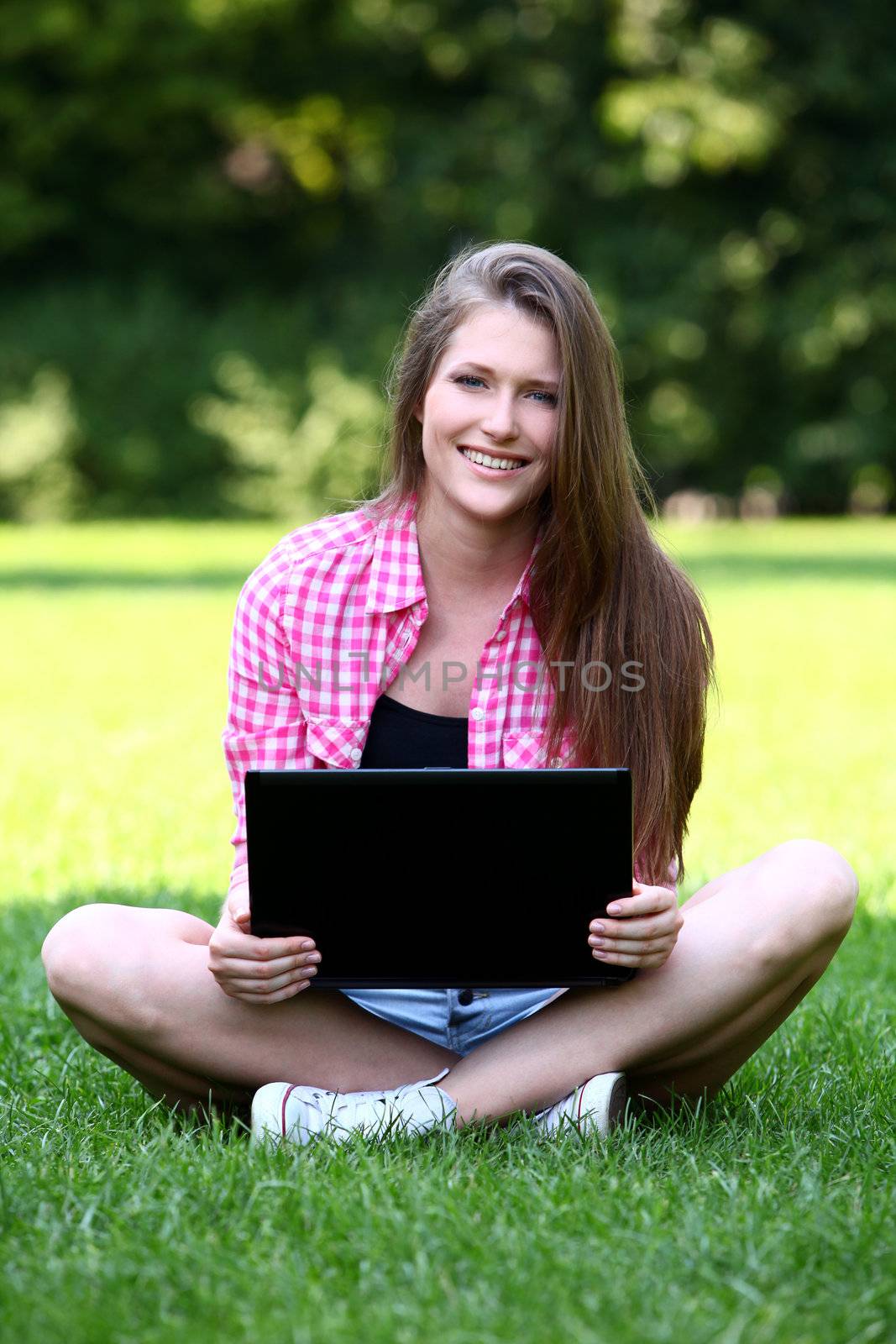 Young and beautiful woman with laptop in park